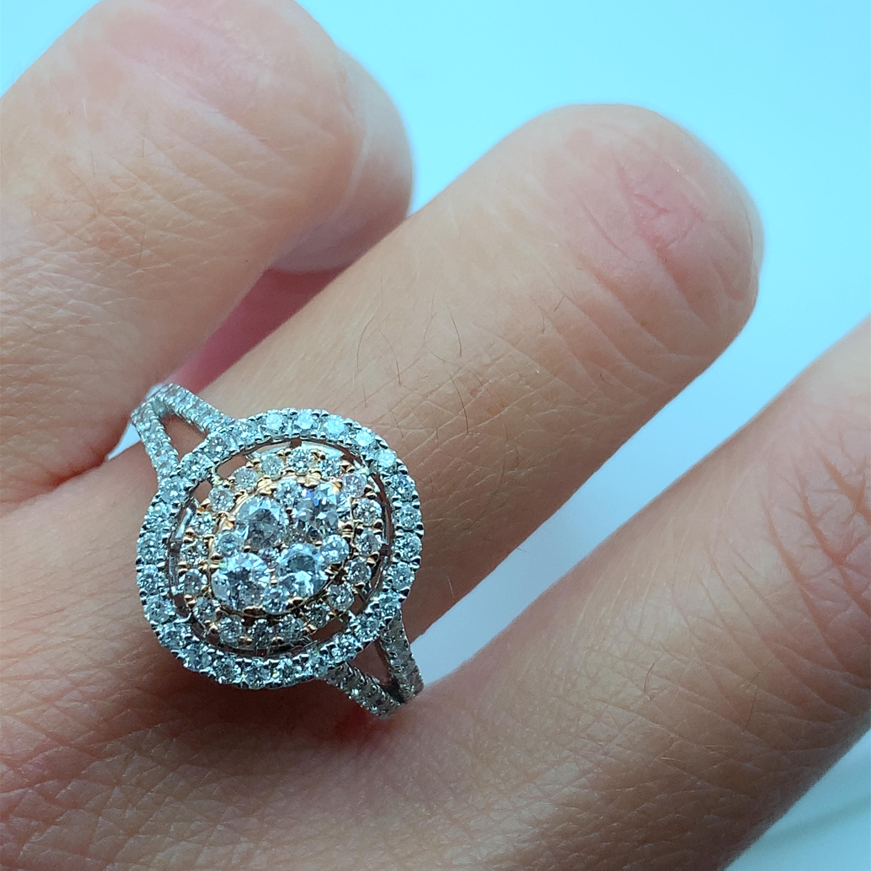 Questo squisito anello di fidanzamento vanta uno splendido diamante rotondo naturale incastonato a illusione come centro, che forma perfettamente una forma ovale illusoria per esaltare la sua impareggiabile brillantezza. Il diamante è incastonato in