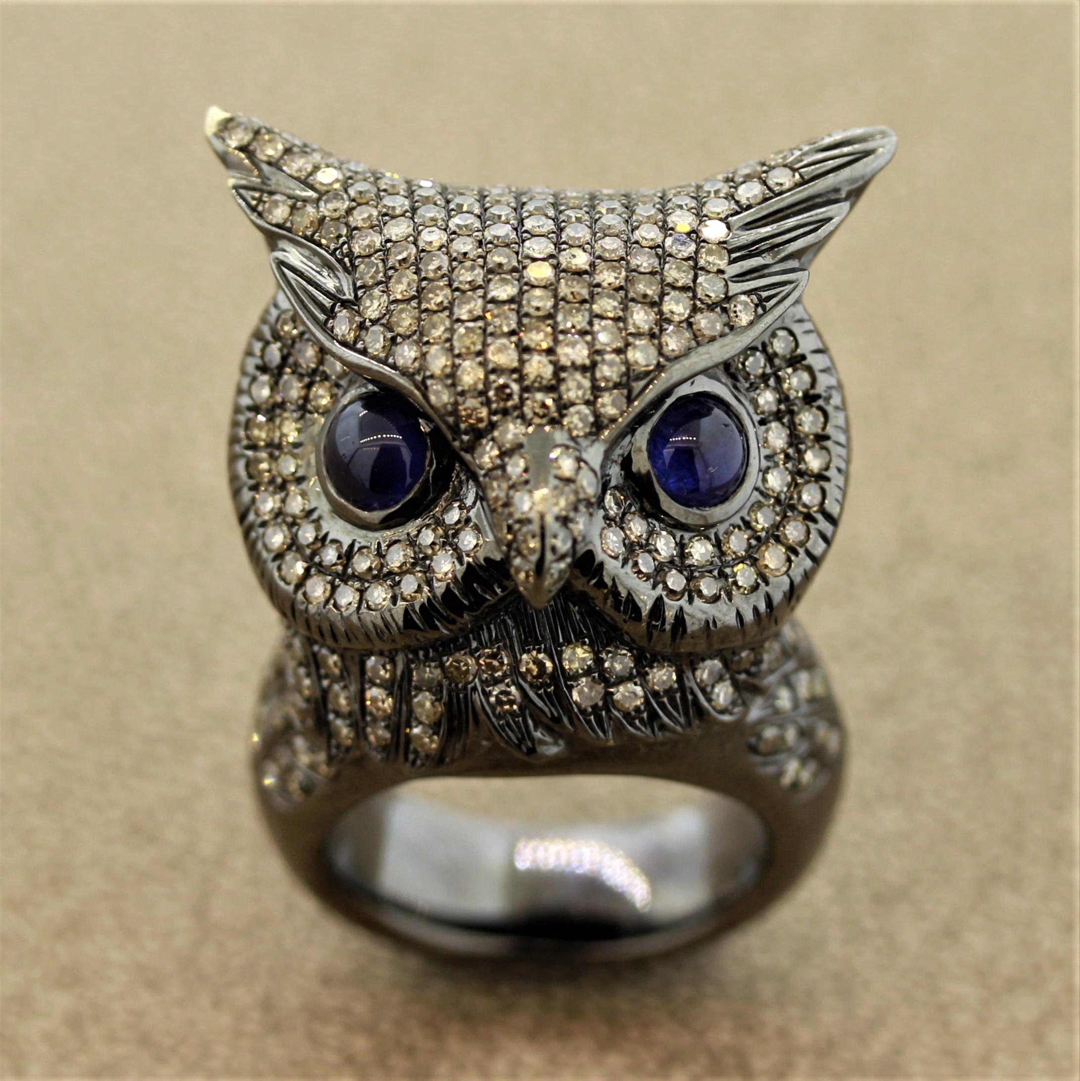 Une bague de chouette superbement réalisée. Elle est ornée de 3,64 carats de diamants naturels de taille ronde et de deux saphirs cabochons servant d'yeux à la chouette. Fabriqué en or 18k avec une finition rhodium noir donnant à la pièce un aspect
