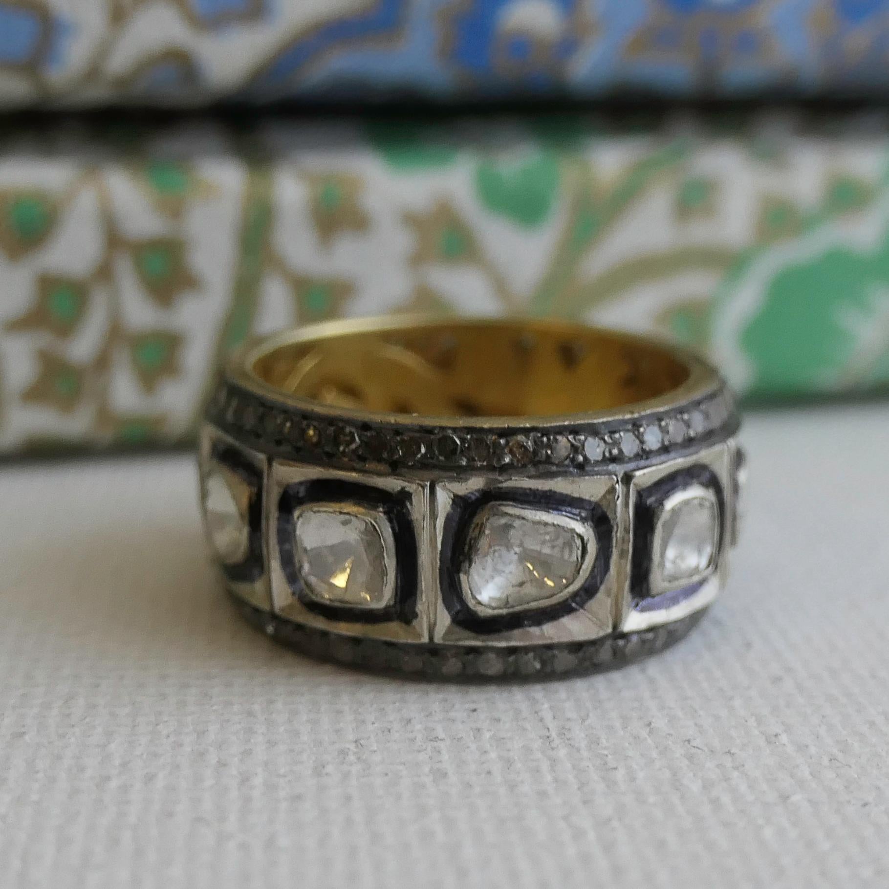 Free form polki diamonds are bezel set in sterling silver. There are oxidized silver detailings and pave diamonds around. 
 Band is 10mm and is gold plated sterling silver. 
 Size 7 