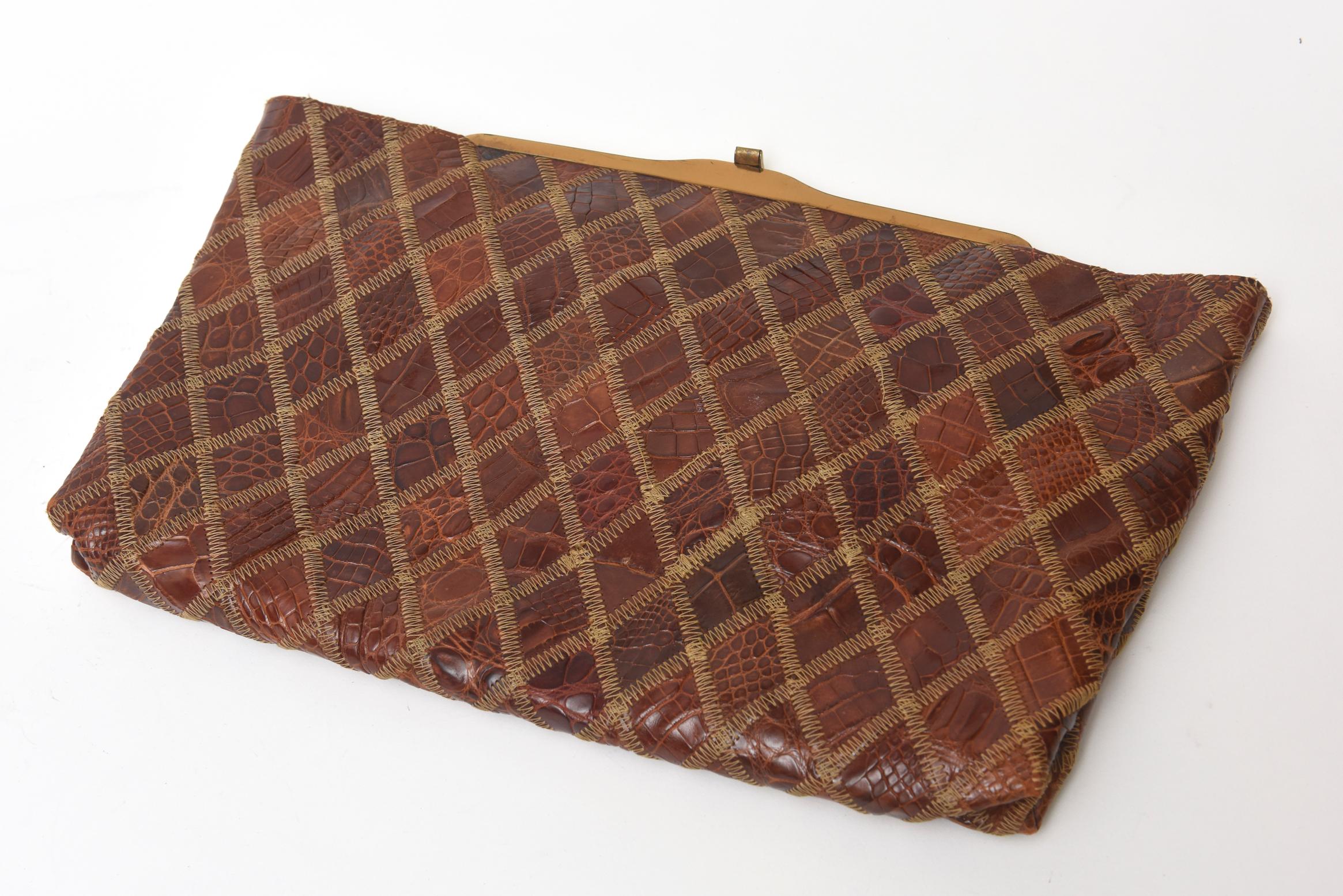 This lovely mid century modern diamond patterned alligator clutch has gold toned hardware and closure. The different tones of brown supple alligator leather make this textural with it's top stitching. It has an enclosure of a small coin purse and a