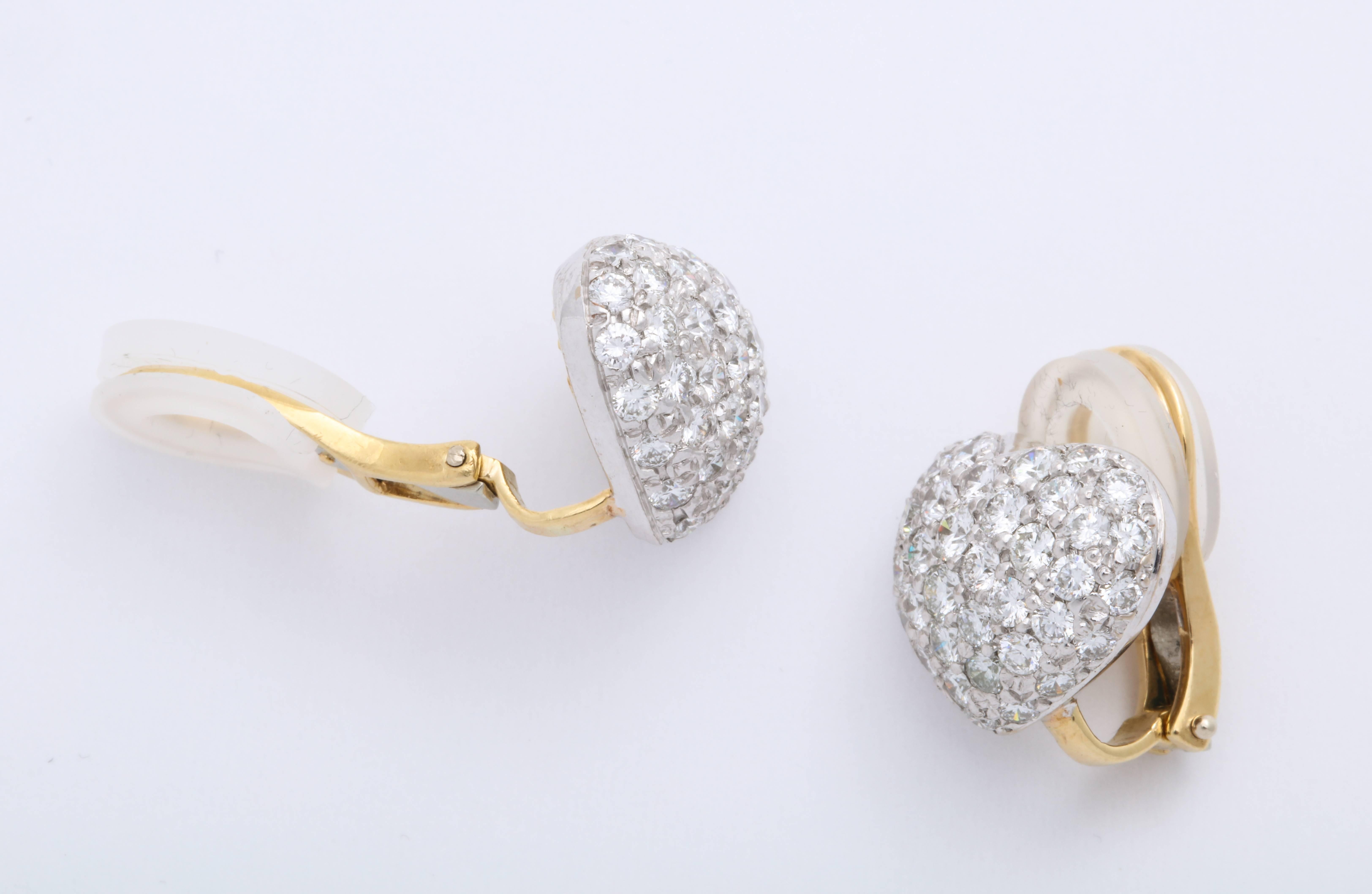 These beautiful domed diamond pave 18 Karat white and yellow gold heart shape earrings are decorated with 4.02 carats of colorless round brilliant-cut diamonds and are set in 18 Karat yellow gold air-line foundation with French clips.

