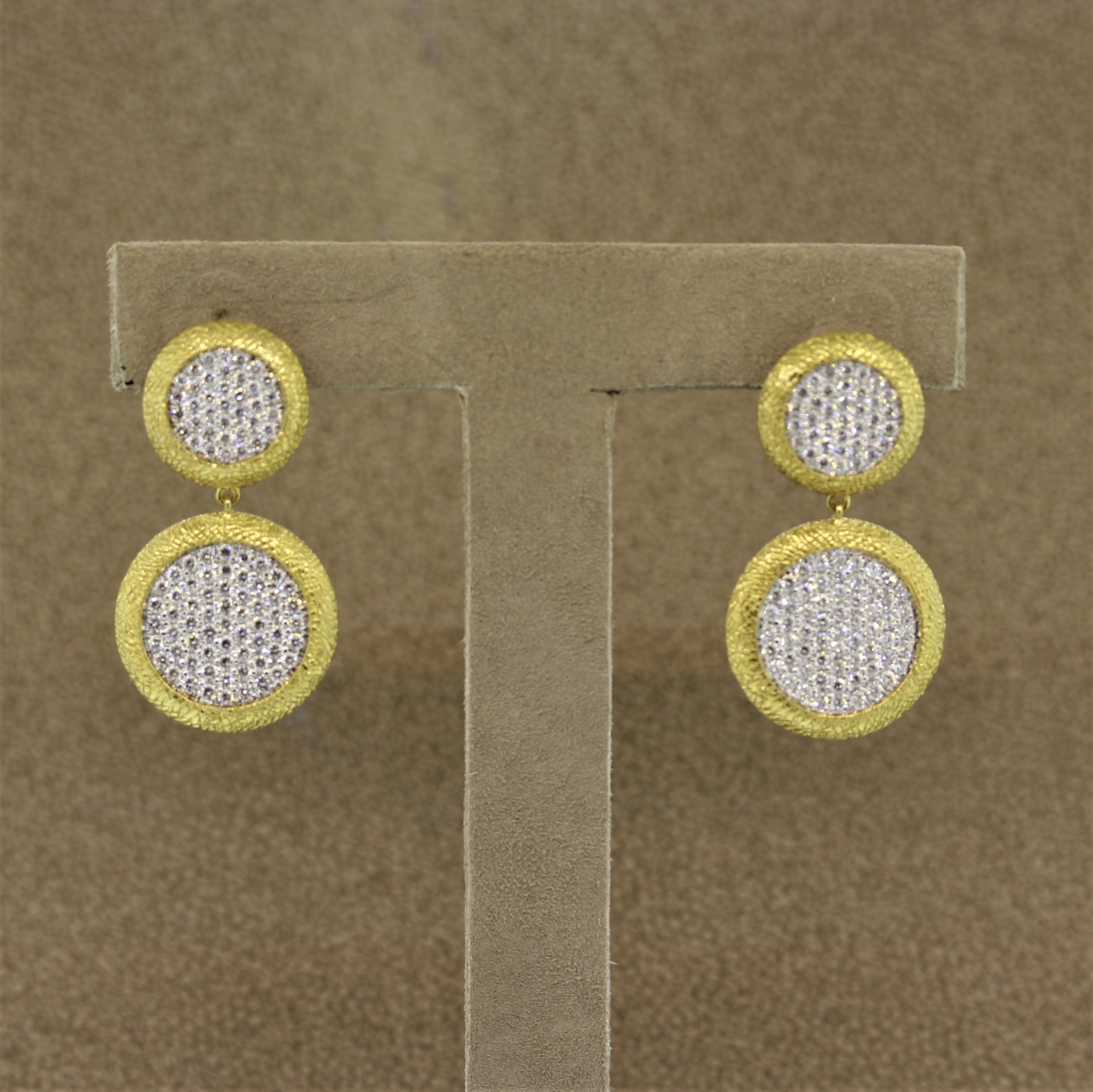 Another favorite of ours, there lovely earrings feature 2.12 carats of fine quality round brilliant cut diamonds which are precisely pavé set in 18k gold. The frames of the discs have a hand styled finish adding to the unique look of the piece. A