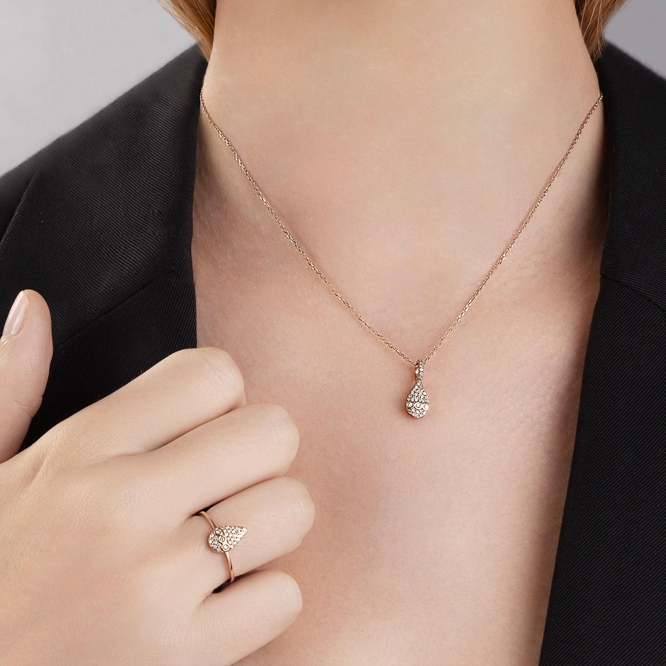 Adornado con una cautivadora silueta en forma de gota, este deslumbrante collar acentúa la belleza de todos los tonos de piel, con su centelleante sinfonía de favorecedores diamantes champán engastados en oro rosa de 18 ct. Emanando una suave