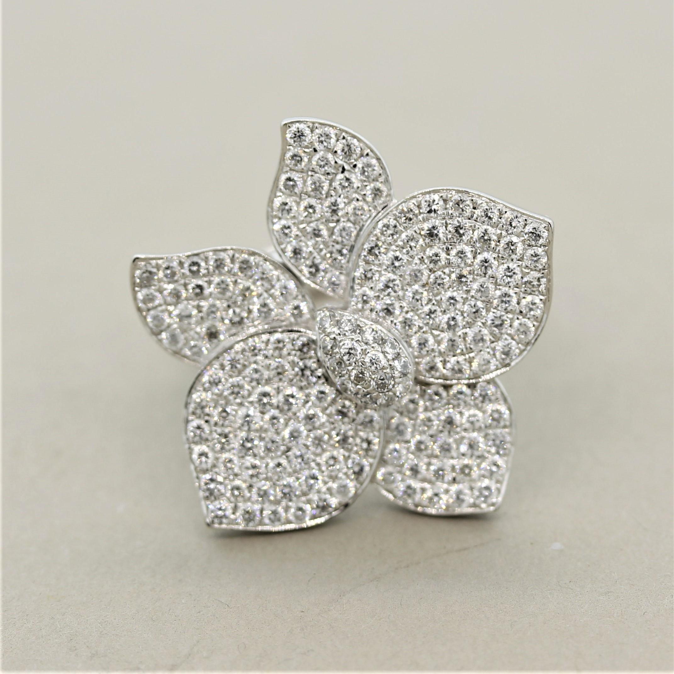 A sweet and stylish cocktail ring! It features 1.70 carats of round brilliant cut diamonds which are pave set over the 5 flower petals and the center piston. Some of the petals are articulated and angled giving the piece a 3-dimensional appearance