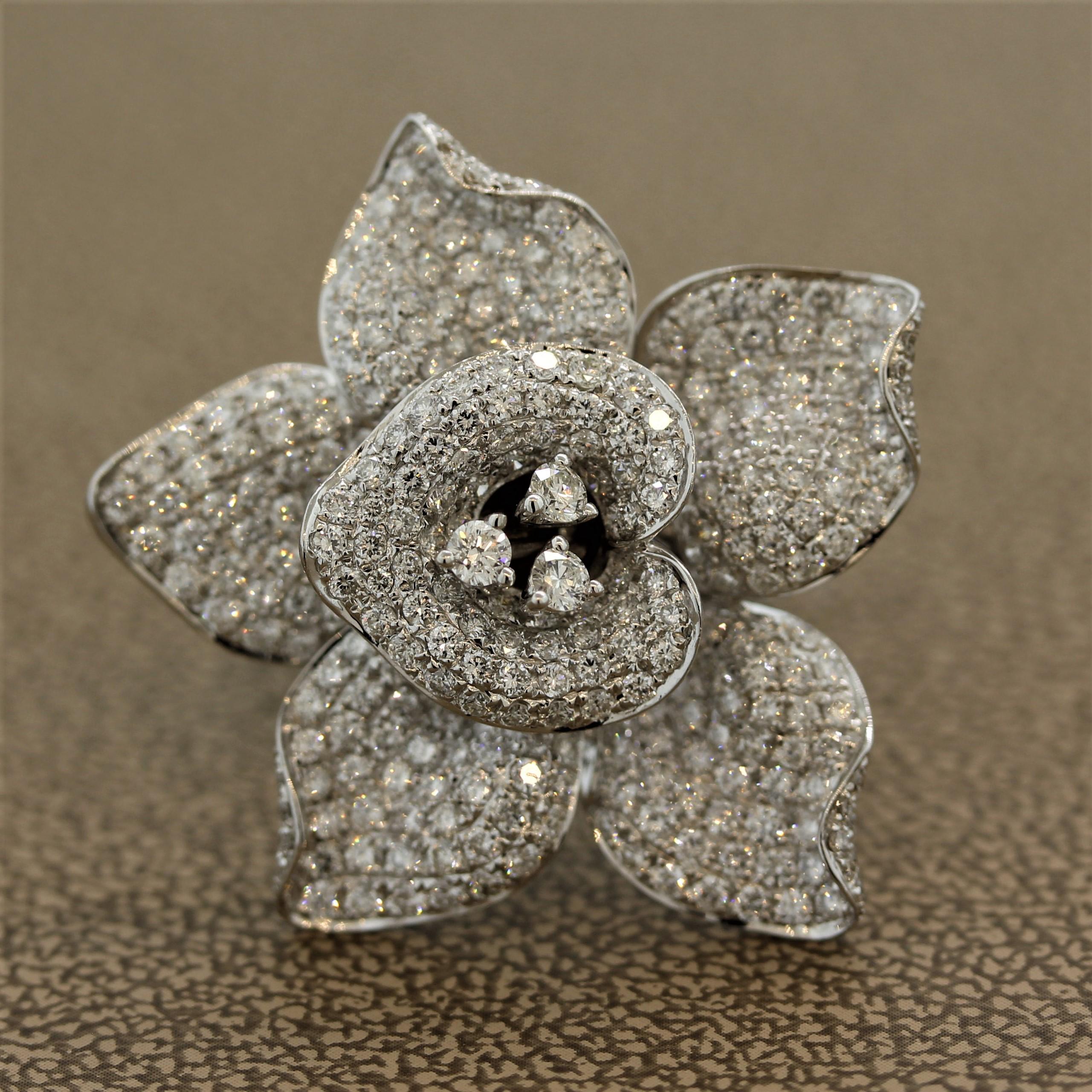 A diamond studded flower in full bloom! This unique piece features pave set round brilliant cut diamonds weighing 2.93 carats. They are set across the entire flower with 3 larger diamonds set in the center. Made in 18k white gold and ready to accent