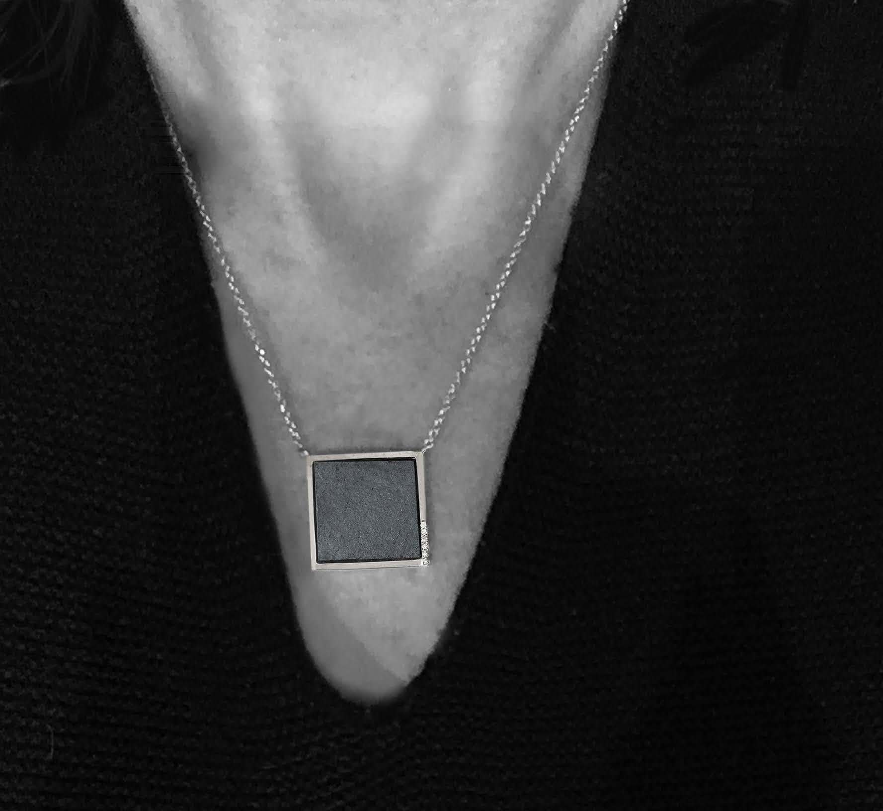 Einzigartig. Dieser ungewöhnliche quadratische Anhänger aus Weißgold mit Diamantpflaster auf rauem Hämatit ist eine Kombination aus Rauheit und Raffinesse. Dieses köstliche Quadrat ist in einer Lünette aus 14k Weißgold gefasst und enthält ca. 0,05