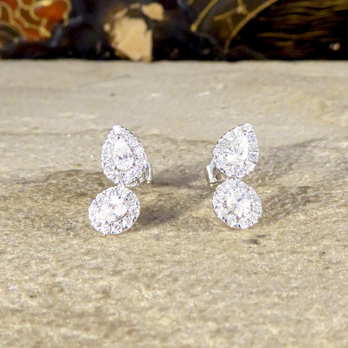 An unusual and eye catching pair of Diamond stud earrings. Each stud features a Pear cut Diamond cluster and an offset Oval cut Diamond cluster sitting just below and creating the most aw-inspiring design. Perfect for anyone who likes an additional