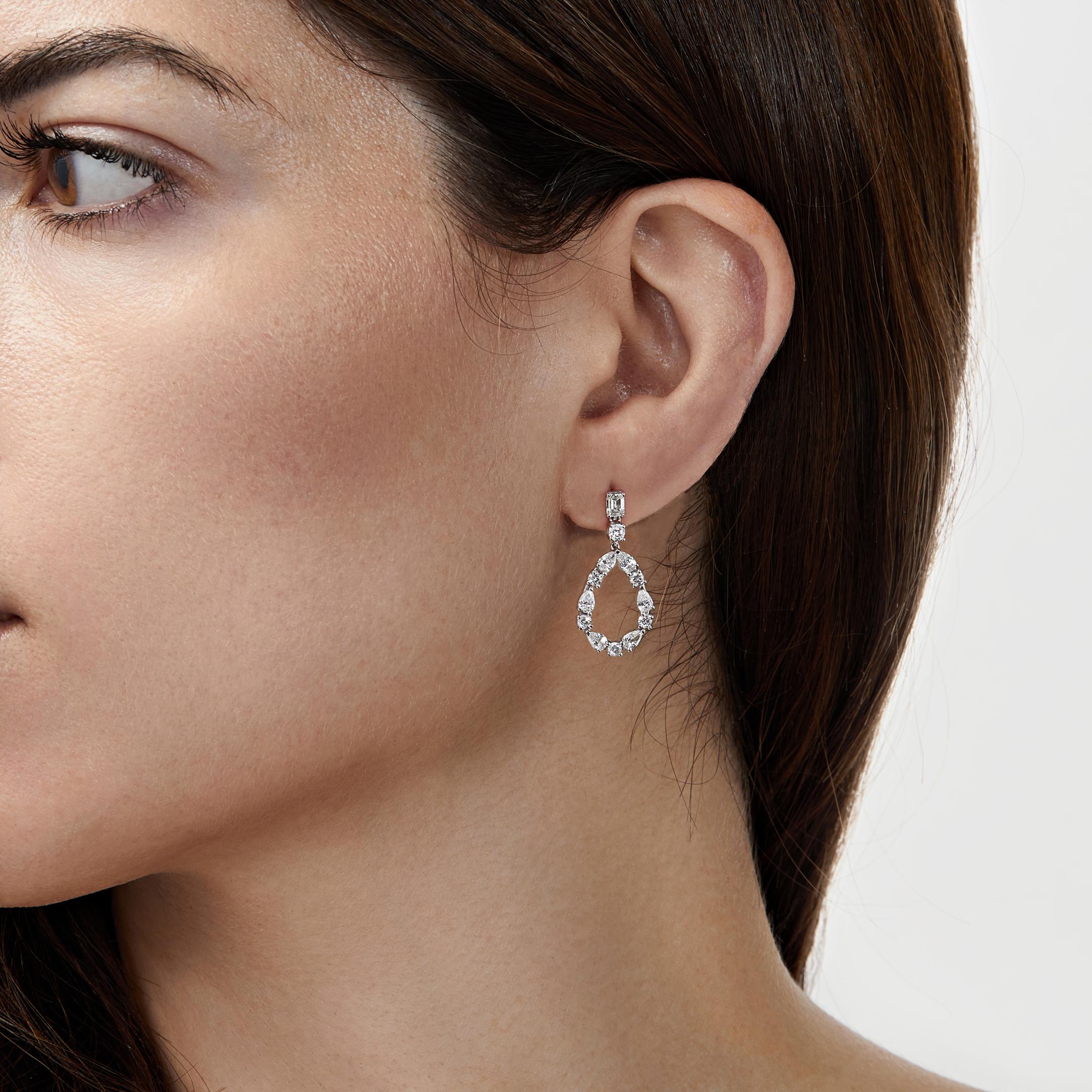A mix of diamond cuts coalesce to create a striking silhouette in the Diamond Pear Cut-Out Earrings. Emerald-cut diamond studs descend into a combination of round brilliant-cut and pear-shaped diamonds arranged in a teardrop shape. Utterly