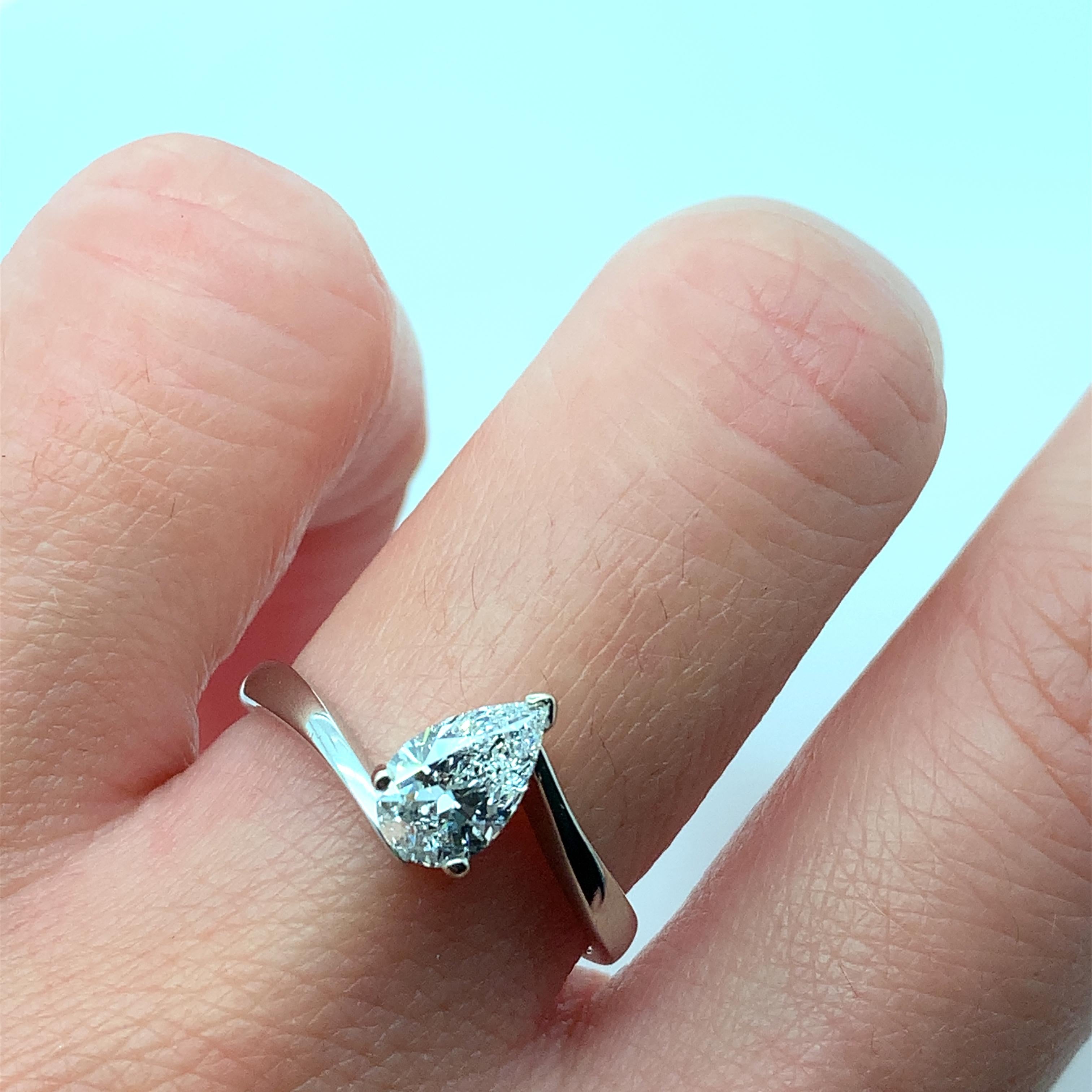 Cette bague de fiançailles exquise est ornée d'un magnifique diamant solitaire en forme de poire serti dans un anneau torsadé en or 18 carats. La bague est ornée d'un total de 0,80 carats et présente un degré de clarté VS1, ce qui en fait un choix