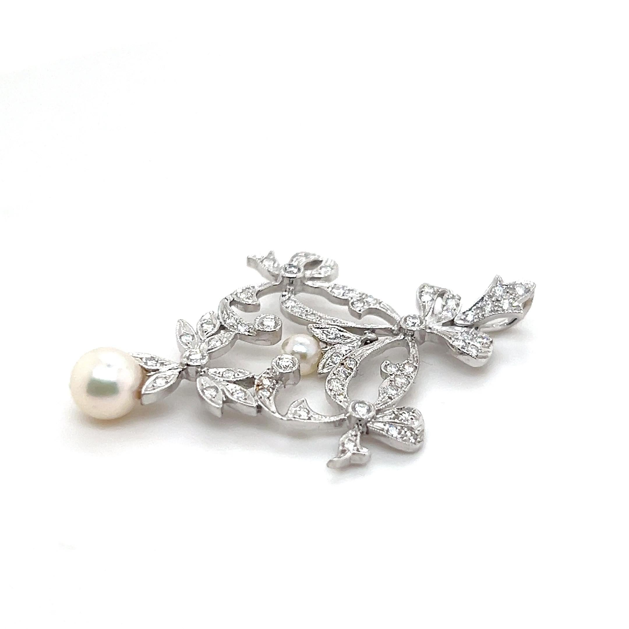 Cet exquis pendentif de reproduction Elegardienne, réalisé en or blanc 18 carats, capture magnifiquement l'élégance d'une époque révolue. Ornée de 61 diamants ronds brillants de couleur G/H et de pureté SI assortis, totalisant 0,51 carat, et de deux