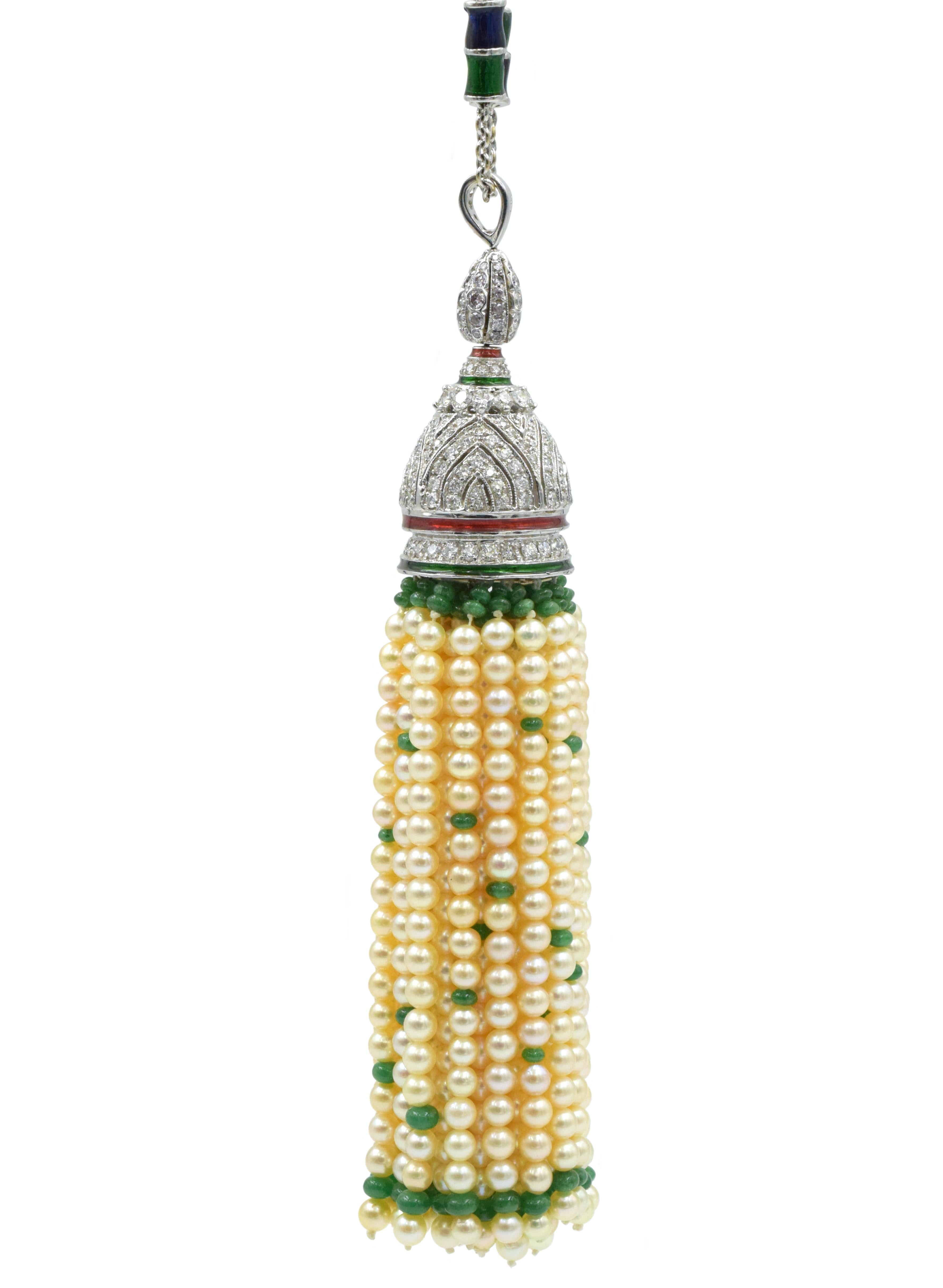Diamond, Pearl and Emerald sautoir necklace has a pendant with a tassel of pearls and emerald beads and a base with round diamond (198 diamonds weighing approx 5.80 carat) and 18k white gold base with red and green enamel rings. 
The chain has blue