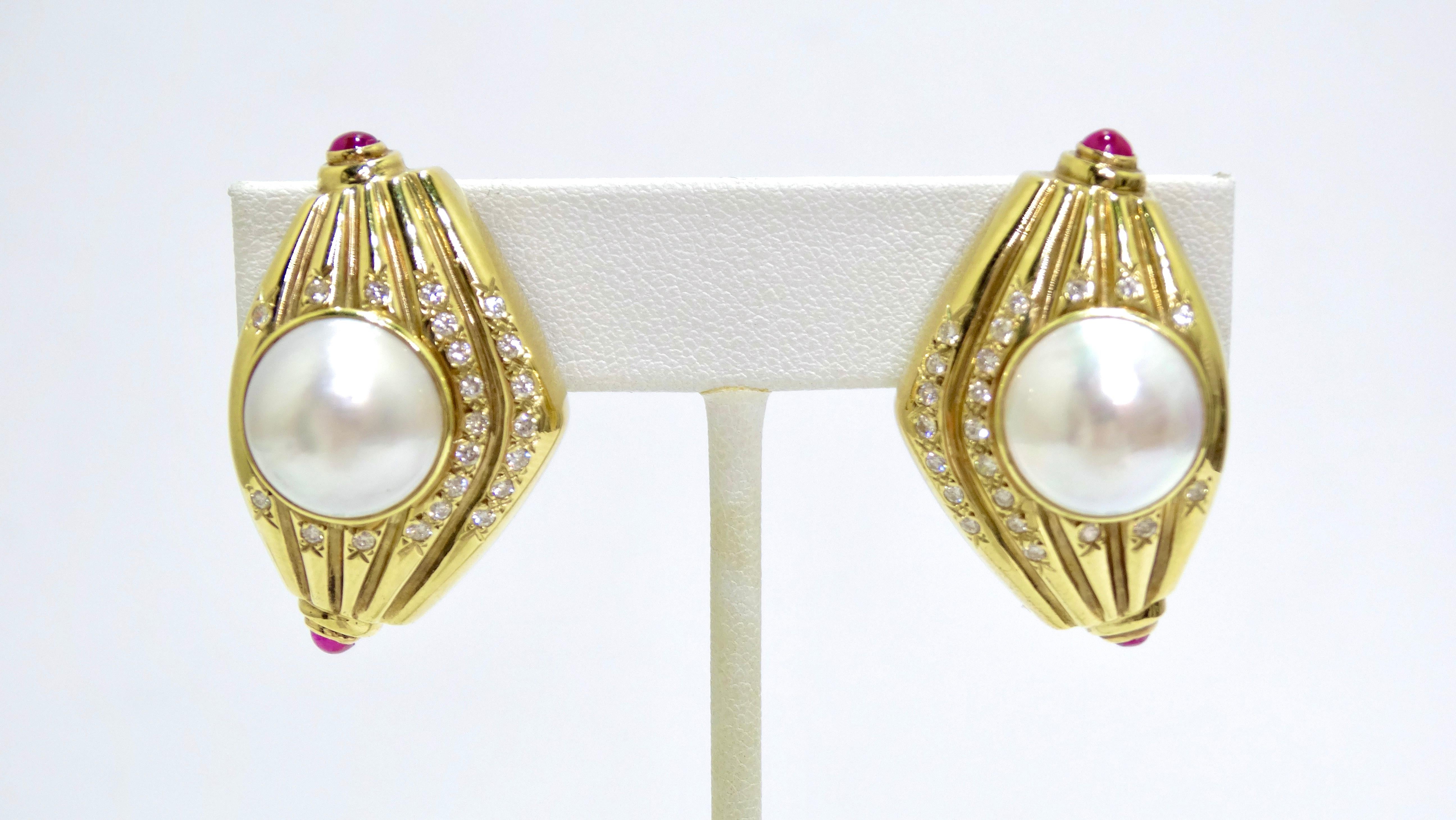 These earrings are feminine and modern in all the best ways. Add elegance to your outfit in one small step. These earrings feature a gold textured teardrop-shape, two huge pearls surrounded by diamonds, and four rubies at all four points of the