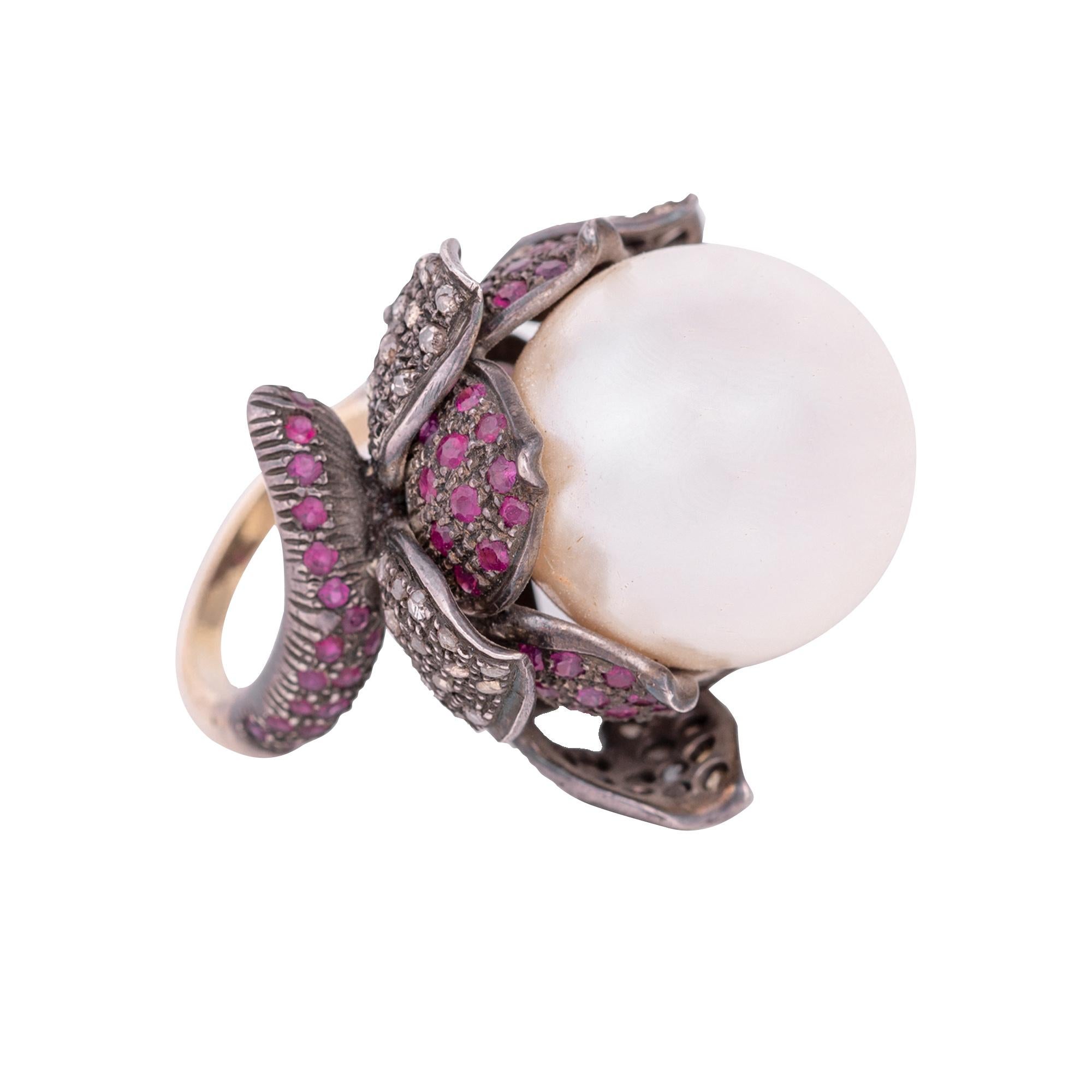Diamond, Pearl, and Ruby Cocktail Flower Ring in Art-Deco Style

This Victorian era art-deco style floral pearl, pink-red ruby and diamond ring is harmonizing. The natural off-white perfect round south-sea pearl solitaire forming the flower’s pistil