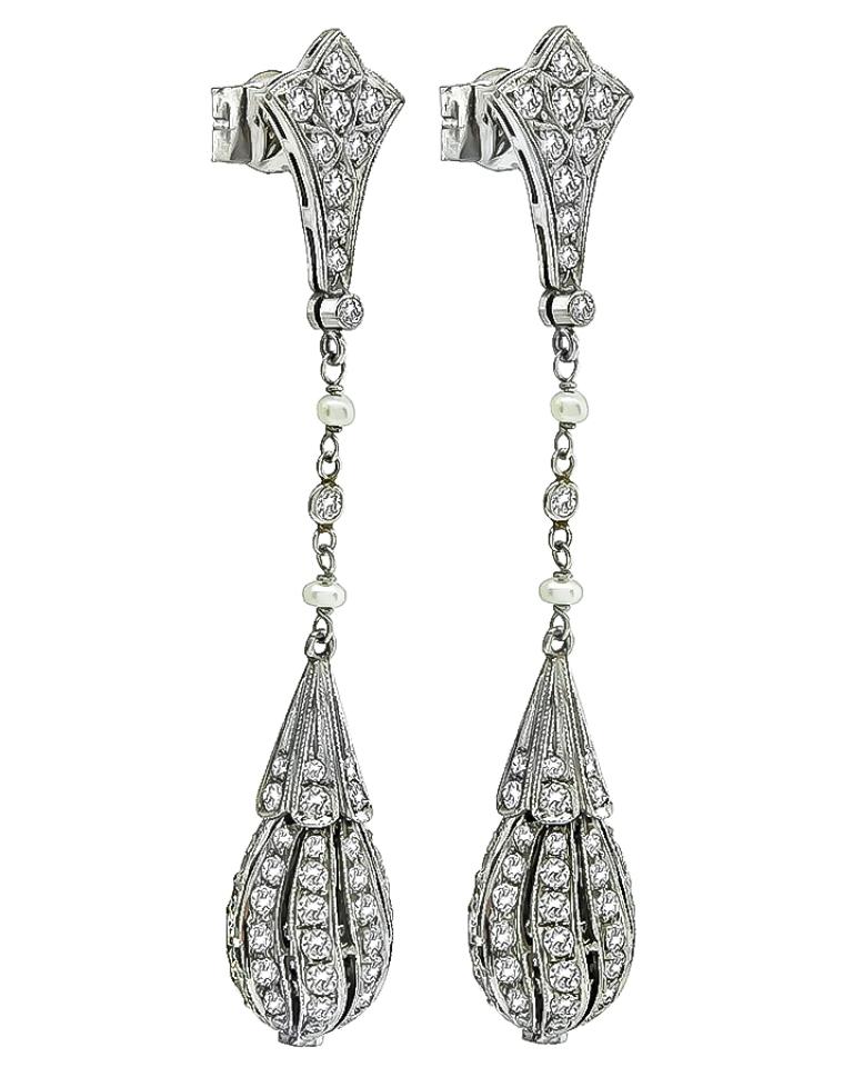 This elegant pair of platinum earrings feature sparkling round cut diamonds that weigh approximately 4.00ct. graded H color with VS clarity. The diamonds are accentuated by lovely pearl accents.
The earrings measure 58mm by 10mm and weigh 7.9