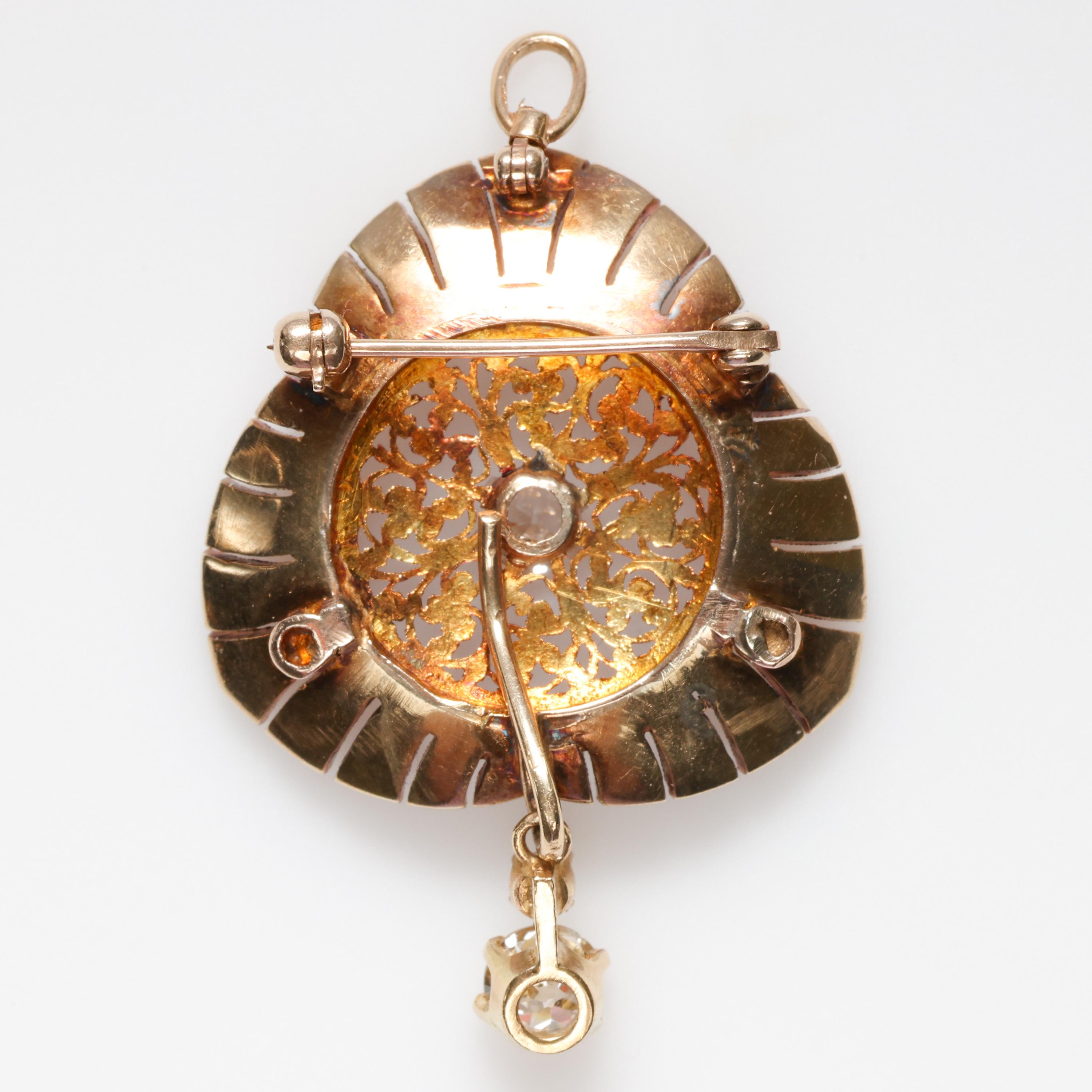 Ornate, exuberant goldsmithing showcases about 1.20 carats of 42 glittering antique rose-cut diamonds and approximately .85 carats of Old European cut stones in this magnificent, baroque-revival pendant /brooch from around 1940.  The total diamond