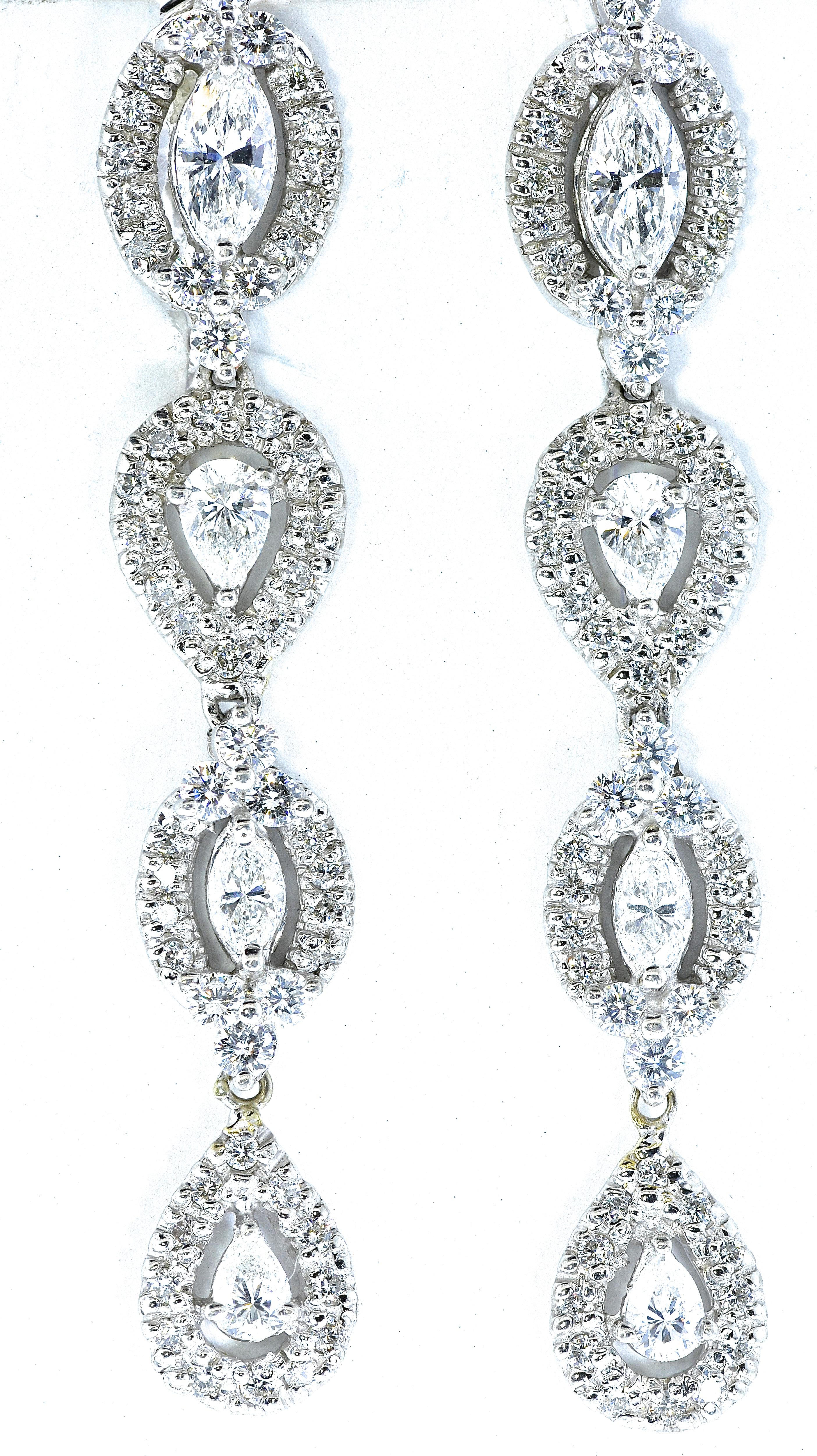Diamond earrings possess fine white well cut and well matched diamonds -  well cut and very white (G/H,VS).  There are approximately 3.2 cts. of round, pear and marquis cut diamonds set in 18K white gold.  These earrings are two inches long.   They