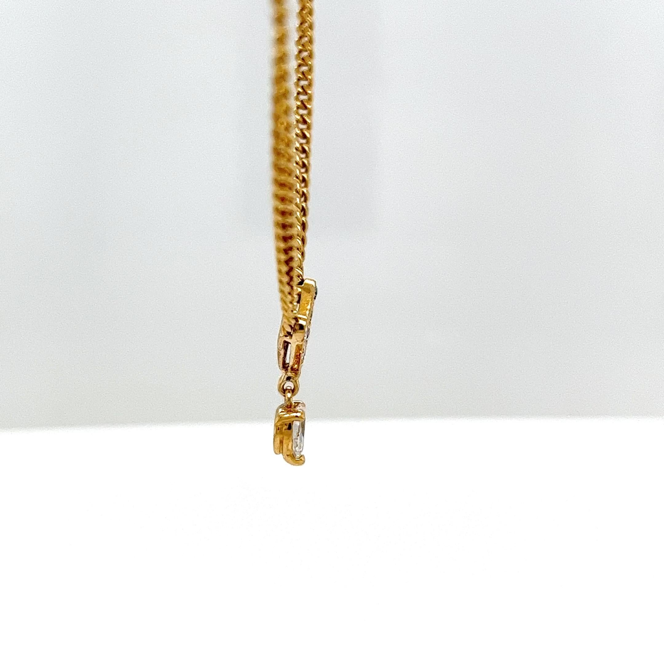 Ce pendentif élégant et raffiné en or jaune 18 ct présente une élégante forme en V qui suspend gracieusement un étincelant diamant en forme de poire. Le pendentif est suspendu à une chaîne classique de 15 pouces, créant un look intemporel adapté à