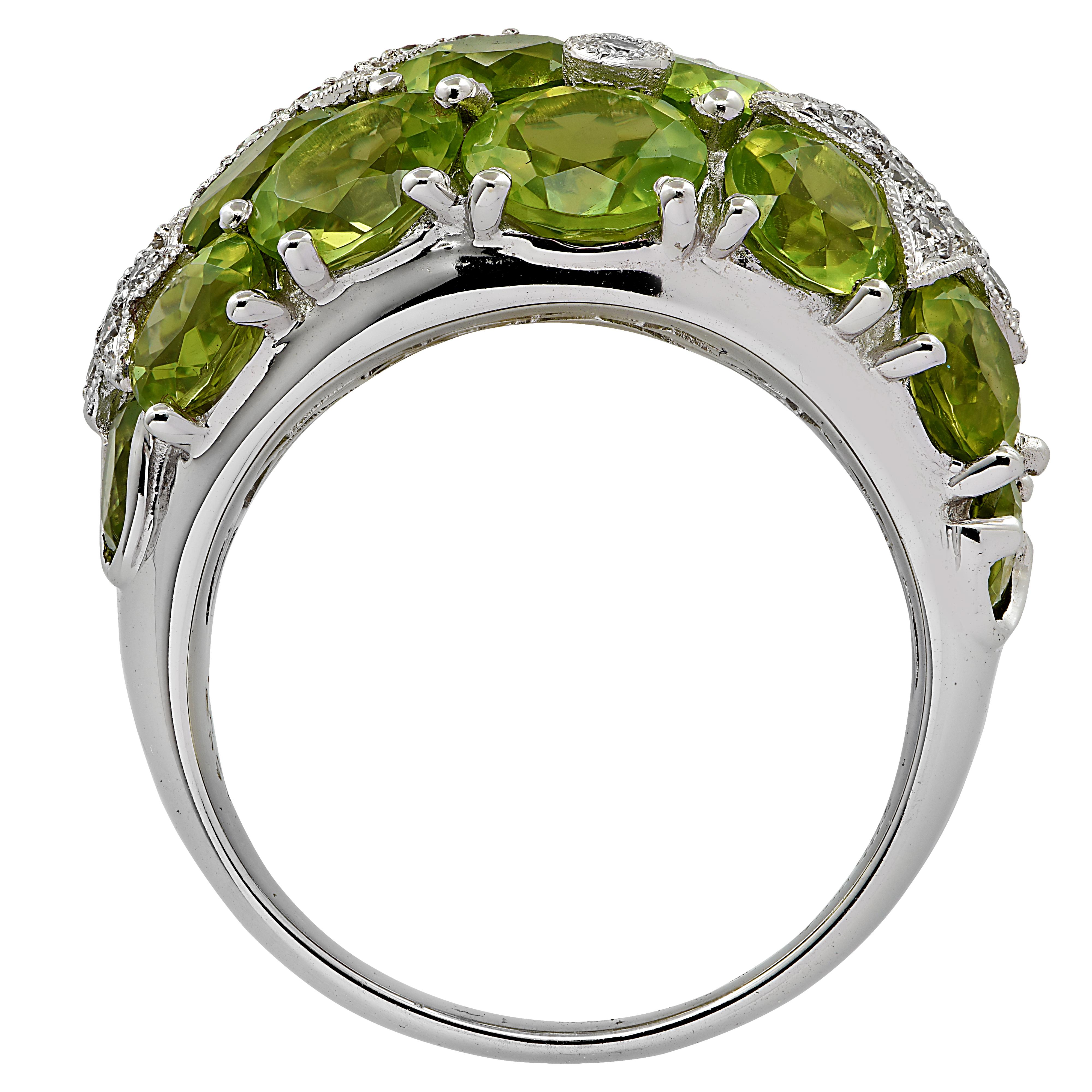 Enchanting ring crafted in 18 karat white gold featuring round brilliant cut diamonds weighing approximately .51 carats G color SI clarity, arranged in diamond encrusted stars, resting on a bed of oval shaped peridots. This delightful ring measures