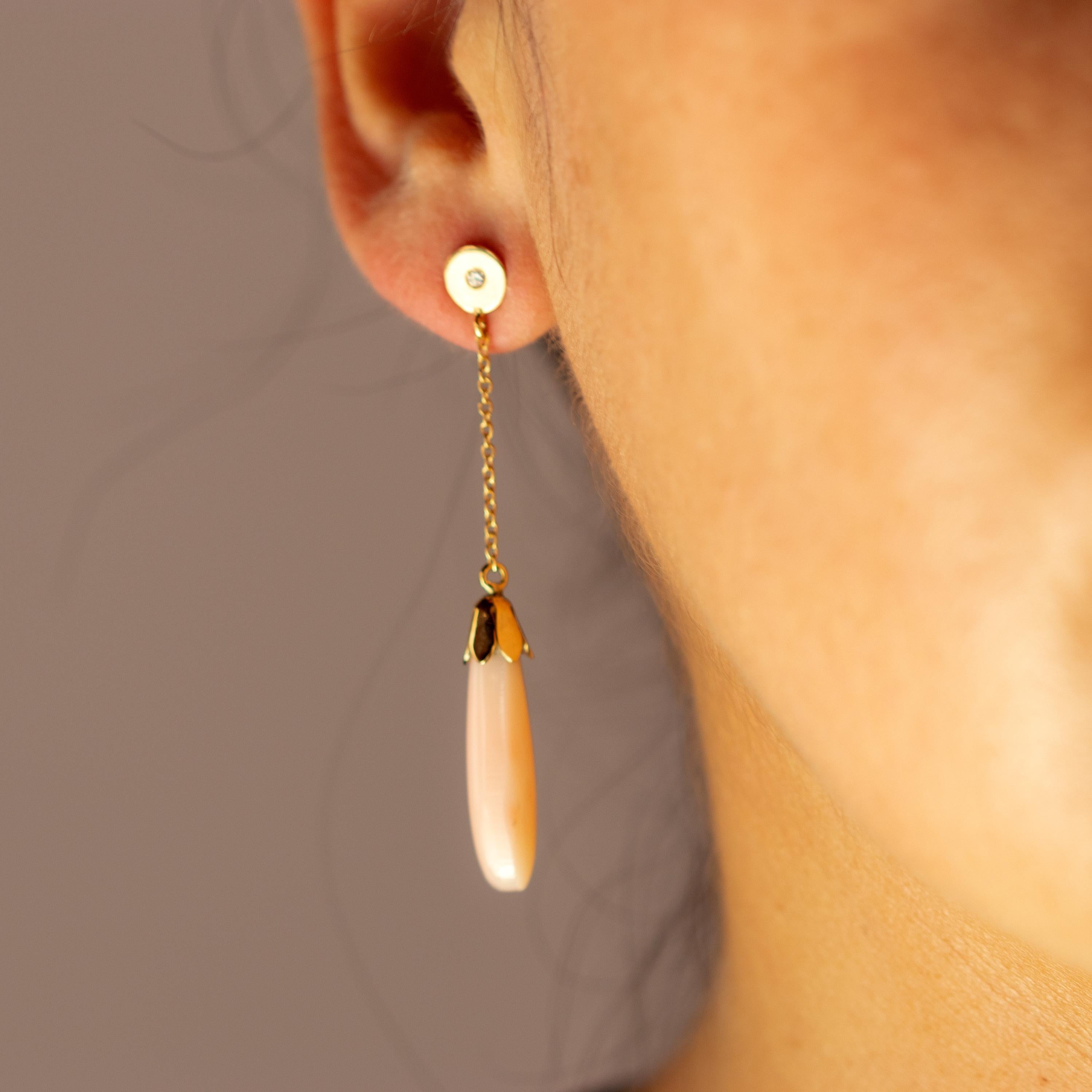 Exotic 0.5 carat diamond and 11 carat coral dangle earrings. The 18 karat yellow gold enhances the piece with a round circle that is connected to a delicate chain holding a beautifully carved and light salmon natural coral long shaped gem.

These