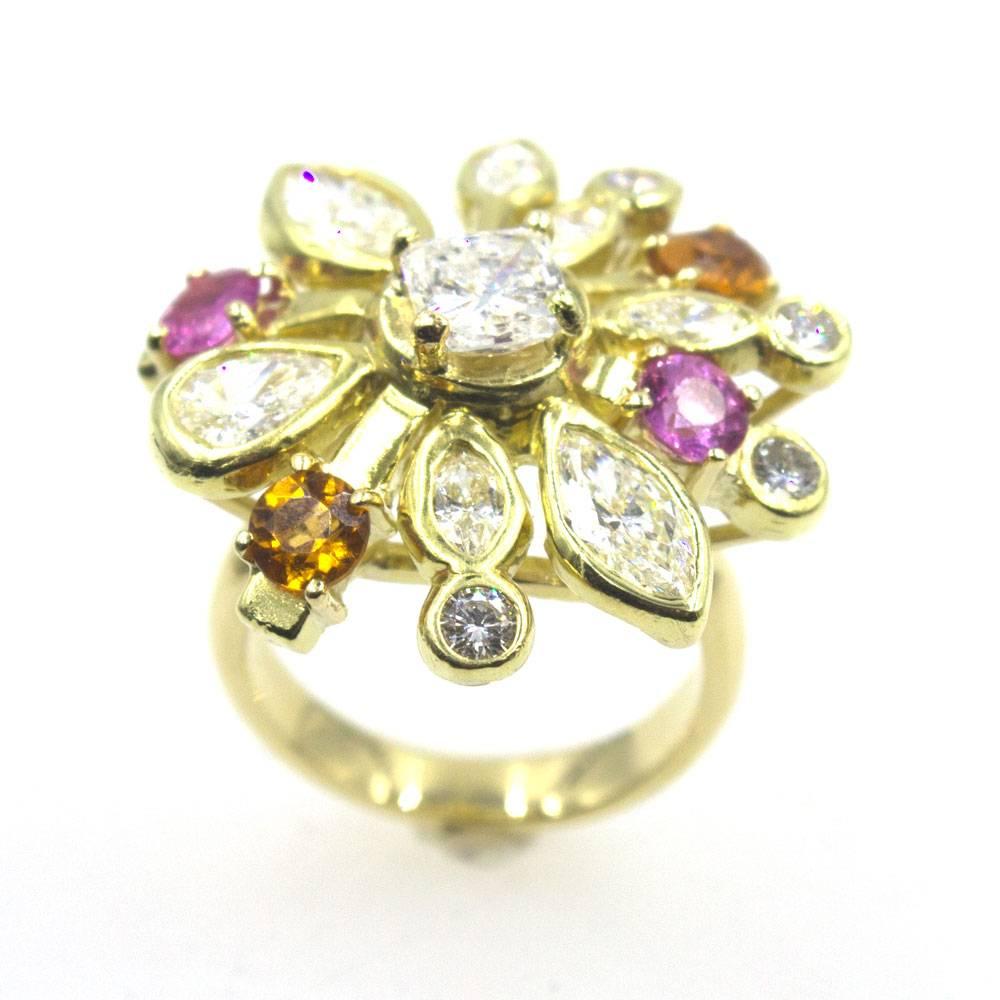 This gorgeous diamond starburst ring is accented with burst of color  (pink sapphire and citrine gemstones). The center features a .91 carat radiant cut diamond surrounded by another 3.75 carats of marquise and round brilliant cut diamonds. The ring