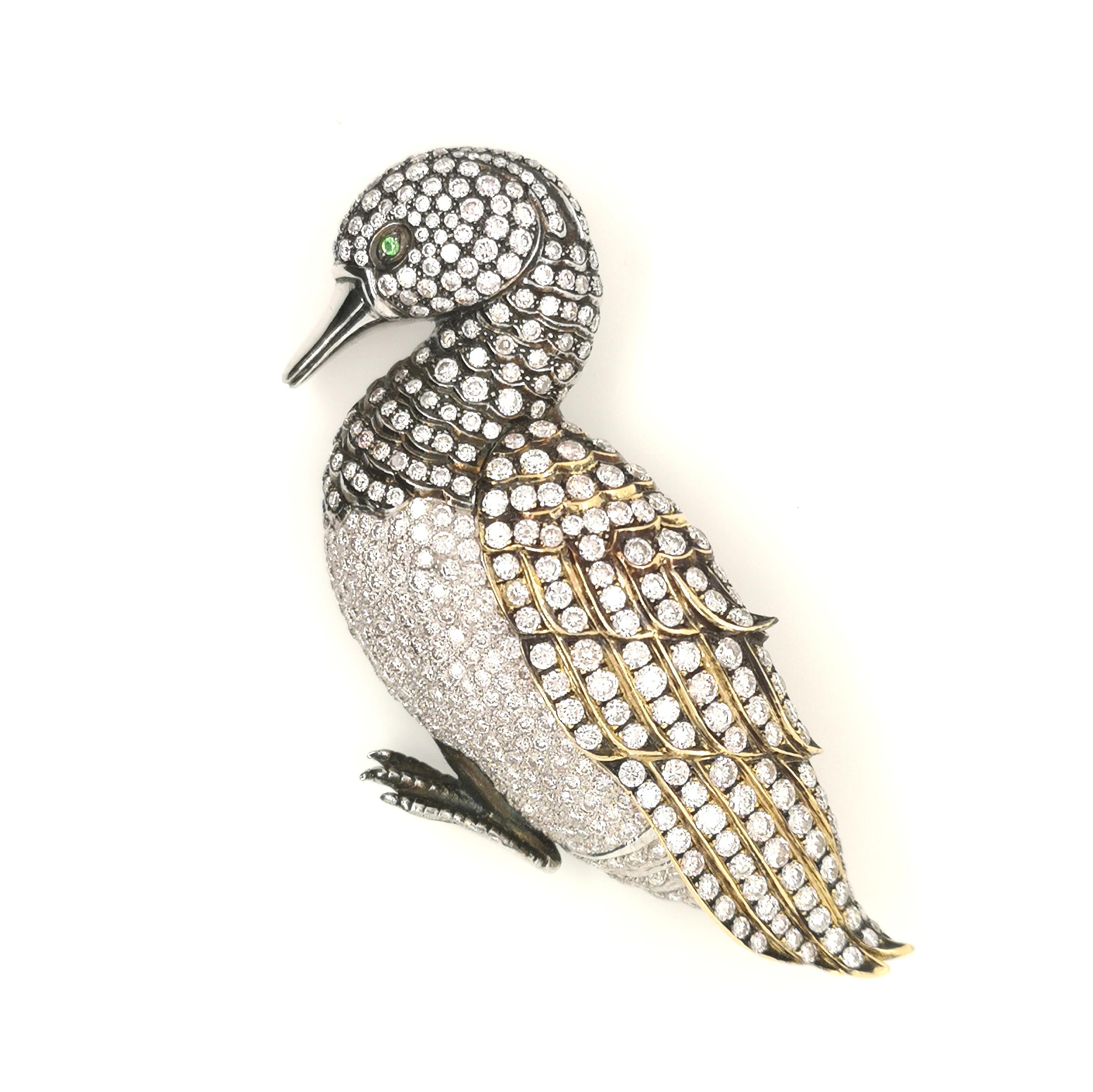 A diamond set duck brooch, round brilliant-cut diamonds set in platinum, with a yellow gold wing and oxidised metal detail to the head, neck and wing, and green garnet eye. Estimated total diamond weight 6.50ct.
Measures approximately 75mm from head