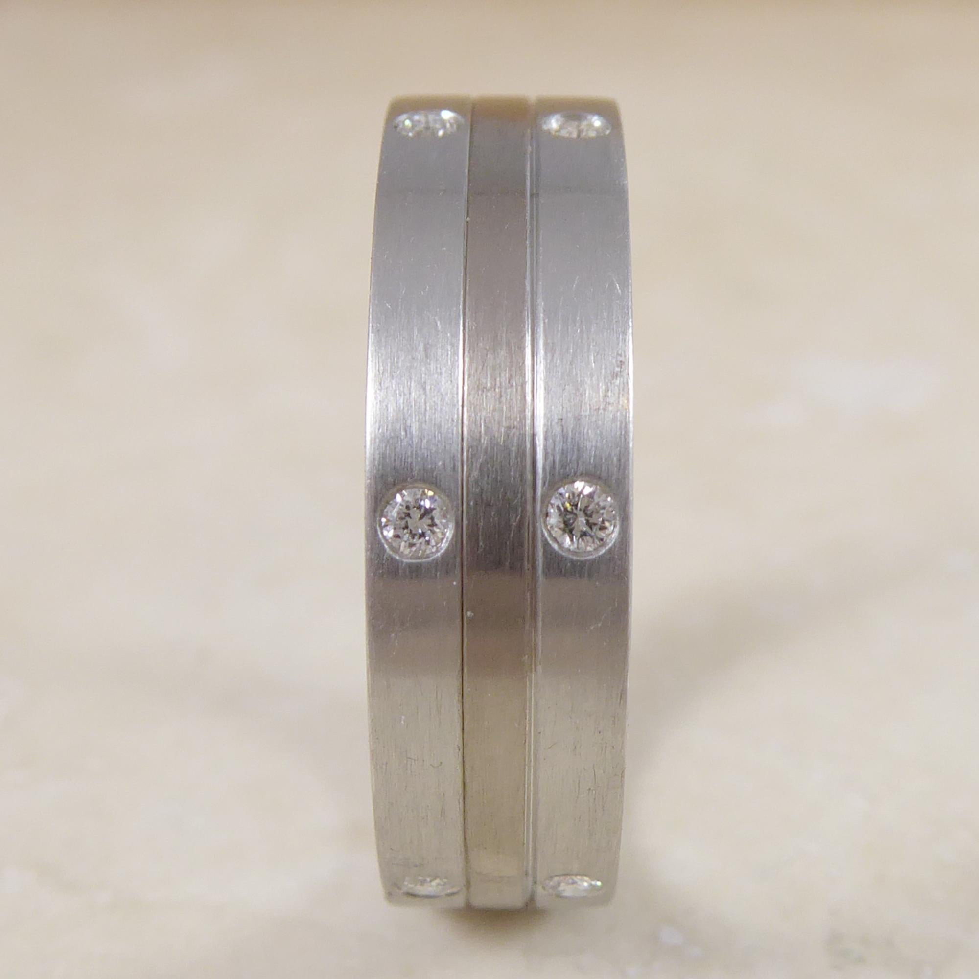 Contemporary design vintage wedding ring, approx. 20 years old and unworn.  The ring comprises three connected, flat cross section white metal bands.  The inner band being platinum with the outer band each side being white gold.  The ring has a
