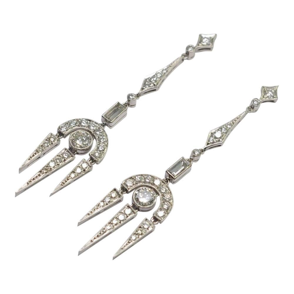 A beautiful pair of vintage diamond chandelier earrings for evening wear.  These are set with transitional and baguette cut diamonds totalling 3ct and mounted in platinum. The diamonds are in millegrain settings with the largest transitional cut