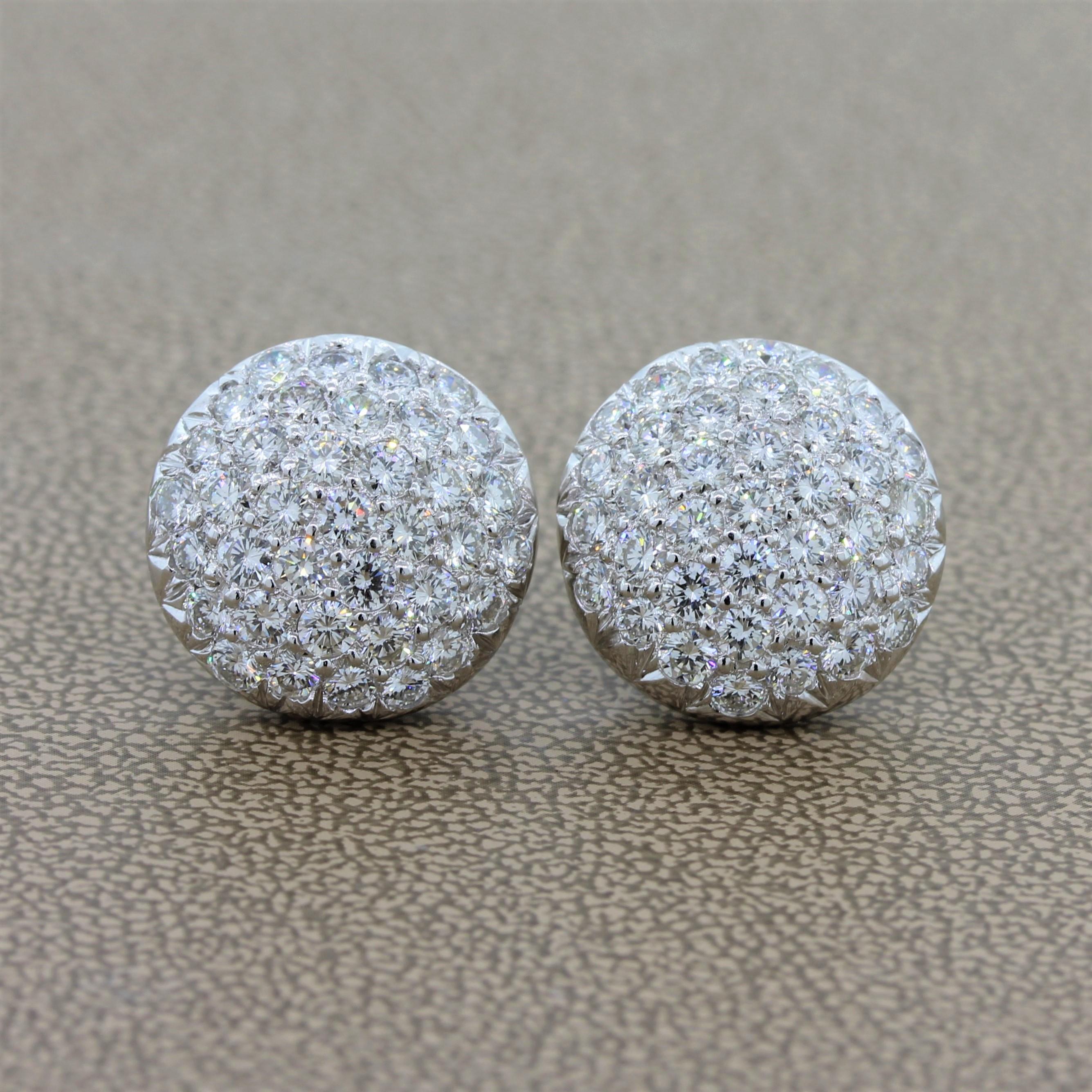 A glamorous pair of button earrings featuring 4.00 carats of VS quality diamonds in a platinum setting. The clustered round cut diamonds are prong set in a slightly convex fashion as these modern earrings gleam with vibrance. A high quality pair of