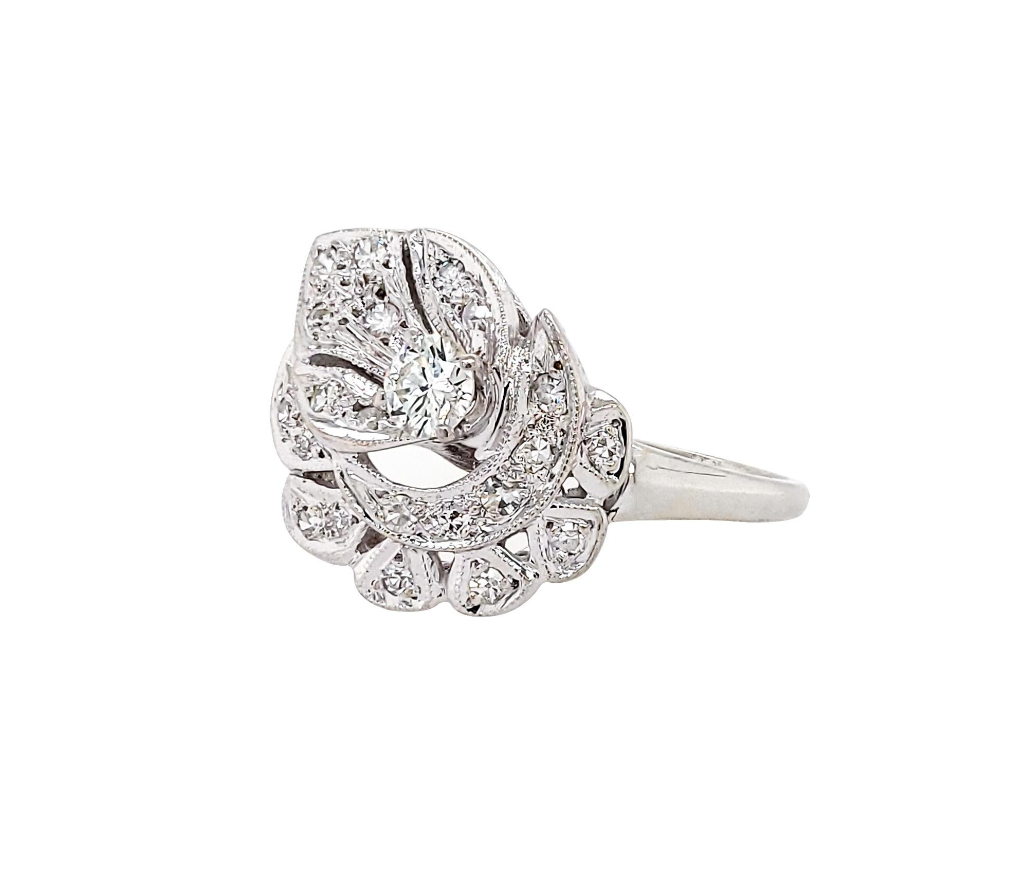 A beautiful vintage cocktail ring made in the late 20th century.
The ring is decorated with a 0.90 carat center diamond and approximately 1 carat of round diamonds.
The metal is platinum weighing 7.10 grams.
Size 12. Resizing available.