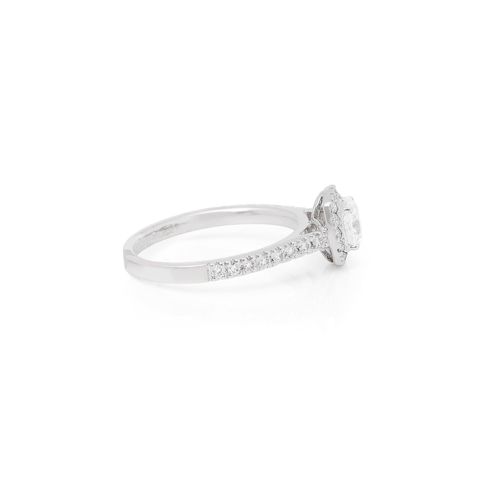 This Ring features a Cushion Cut Diamond to the centre totalling 0.61cts F Colour VS1 Clarity, with Micro Set Round Briliant Cut Diamond Halo and Shoulders totalling 0.32cts. Set in Platinum. Ring size UK L1/2, EU Size 52, USA Size 6. Complete with