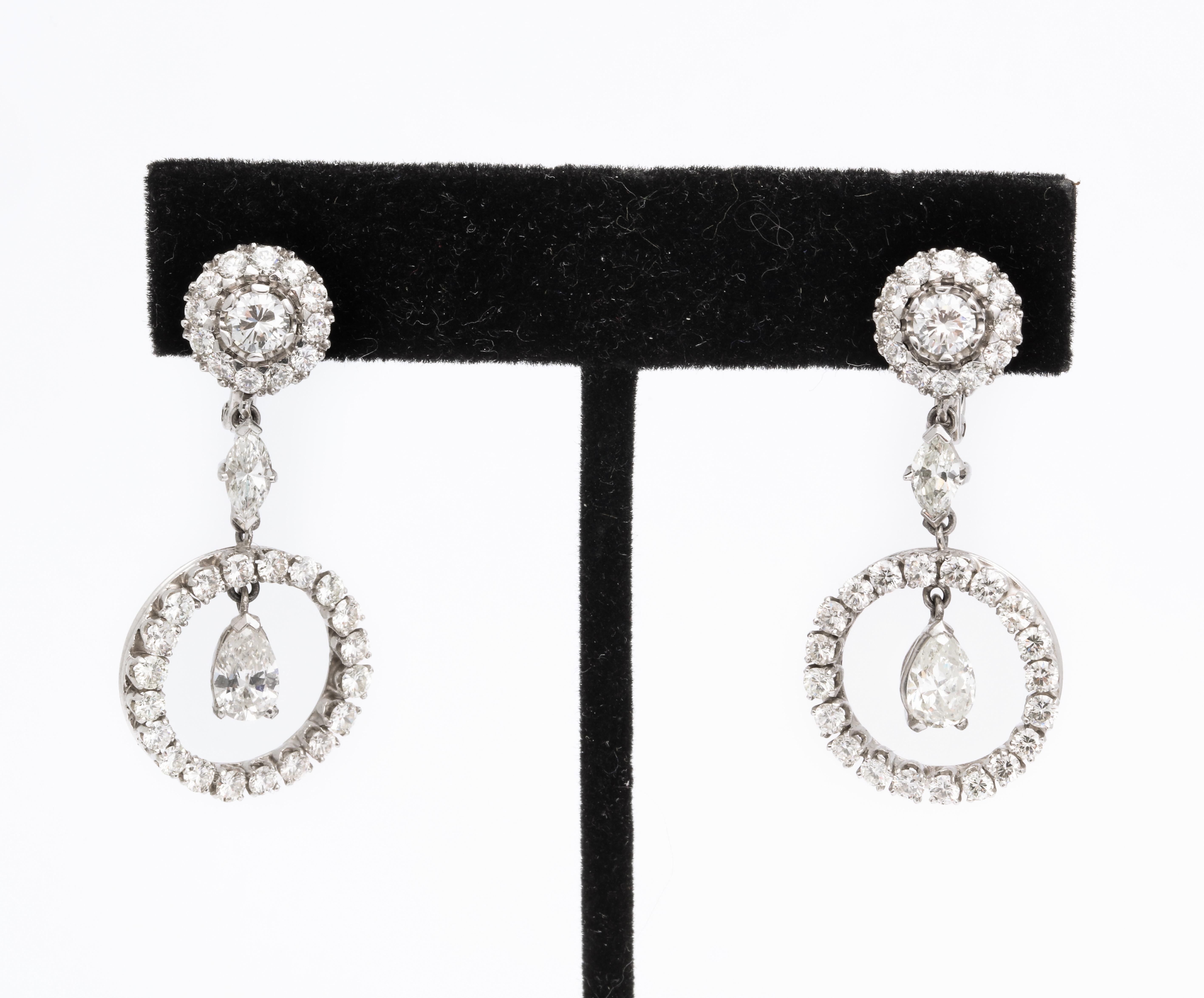 A pair of wonderful Art Deco Style diamond platinum dangle  earrings with pear-shaped diamonds dangling from a circle of diamonds connected by a marquise diamond . They are beautifully designed and comprised of  quality  diamonds.