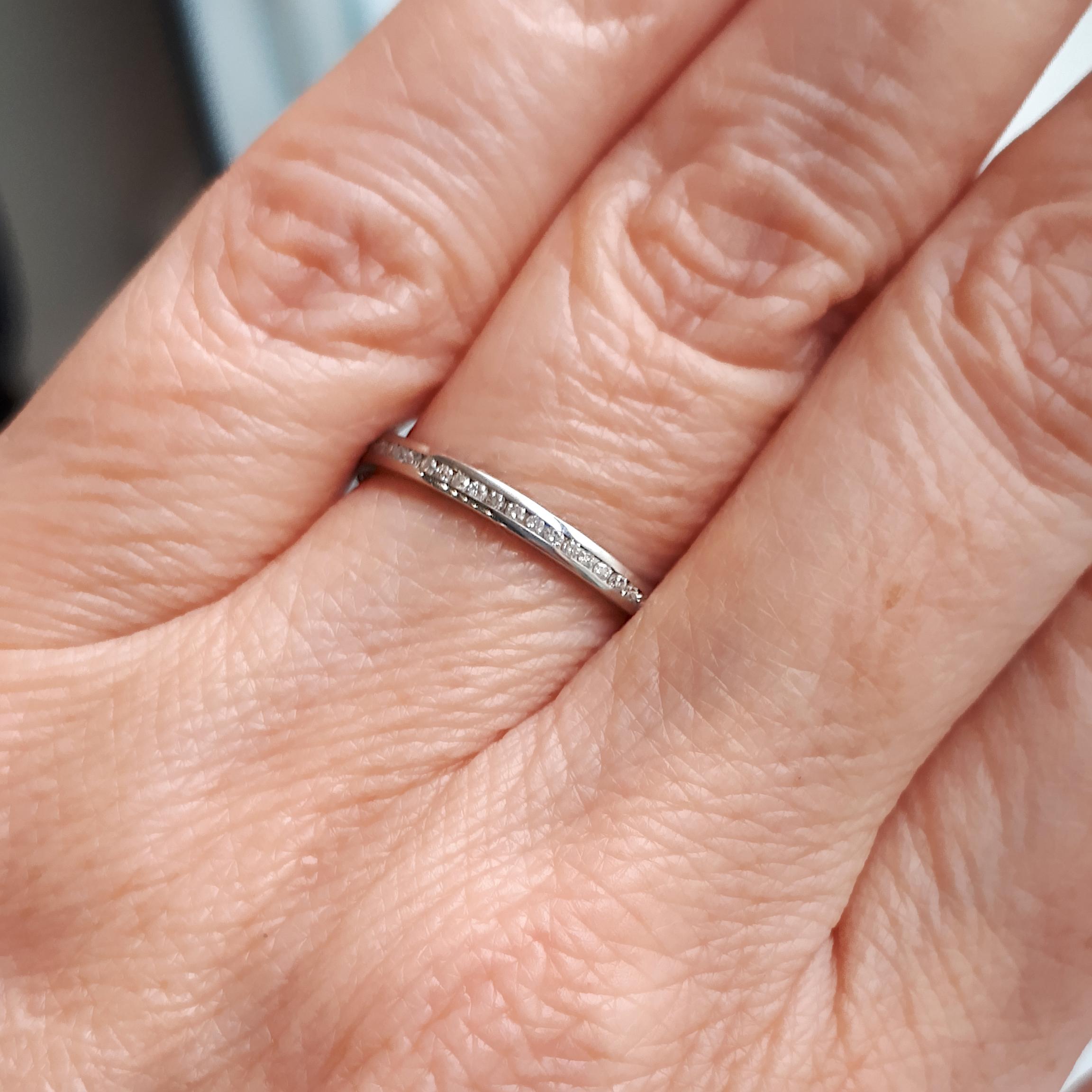 A modern full eternity ring, set with a row of round brilliant-cut diamonds, weighing an estimated total of 0.26 carats, channel set in platinum.