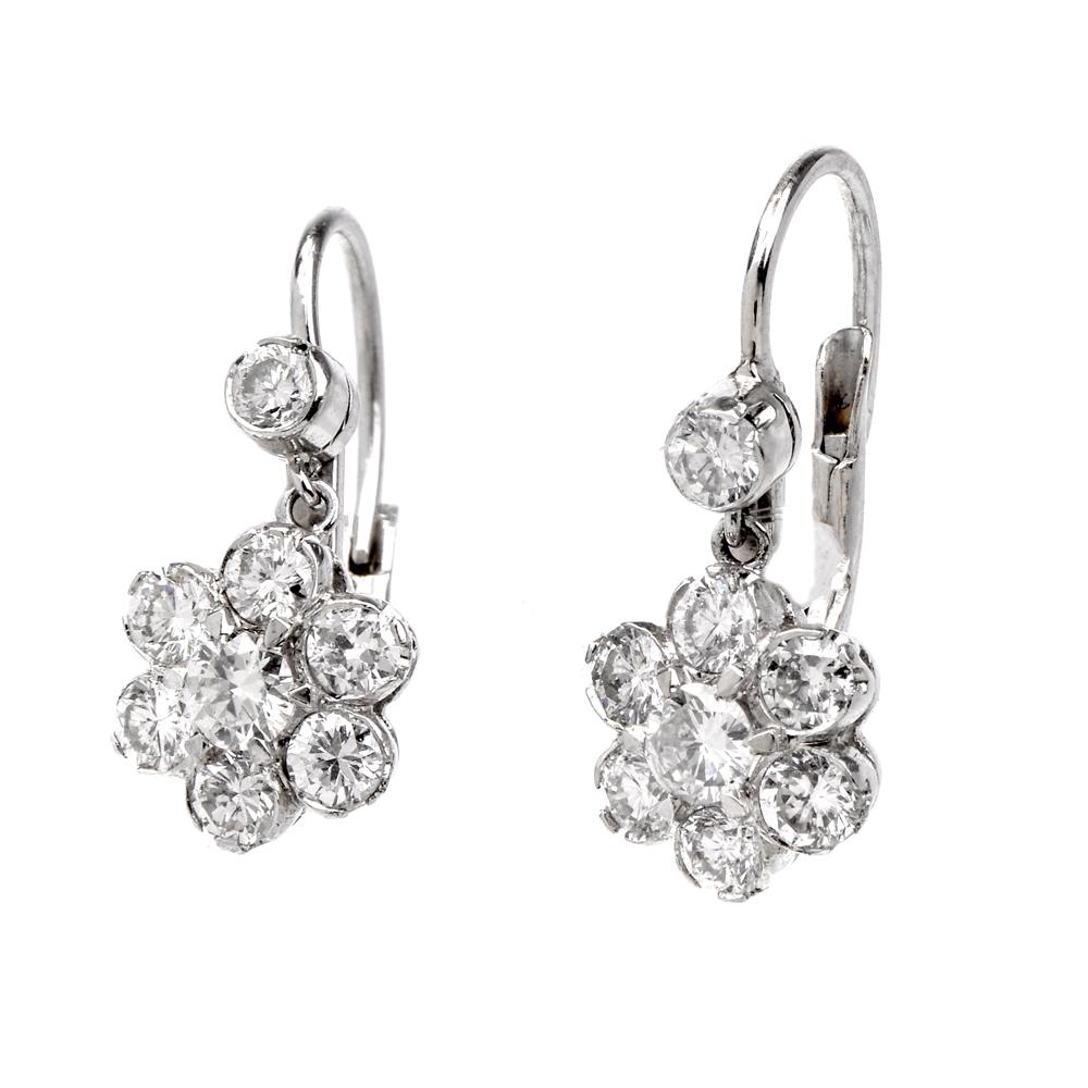 These gracefully feminine diamond earrings are crafted in solid platinum, designed as a pair of vibrant rosette motif profiles, enriched with 16 round-cut suspending from a sparkling diamond colett. The precious stones weigh collectively 1.50 carats