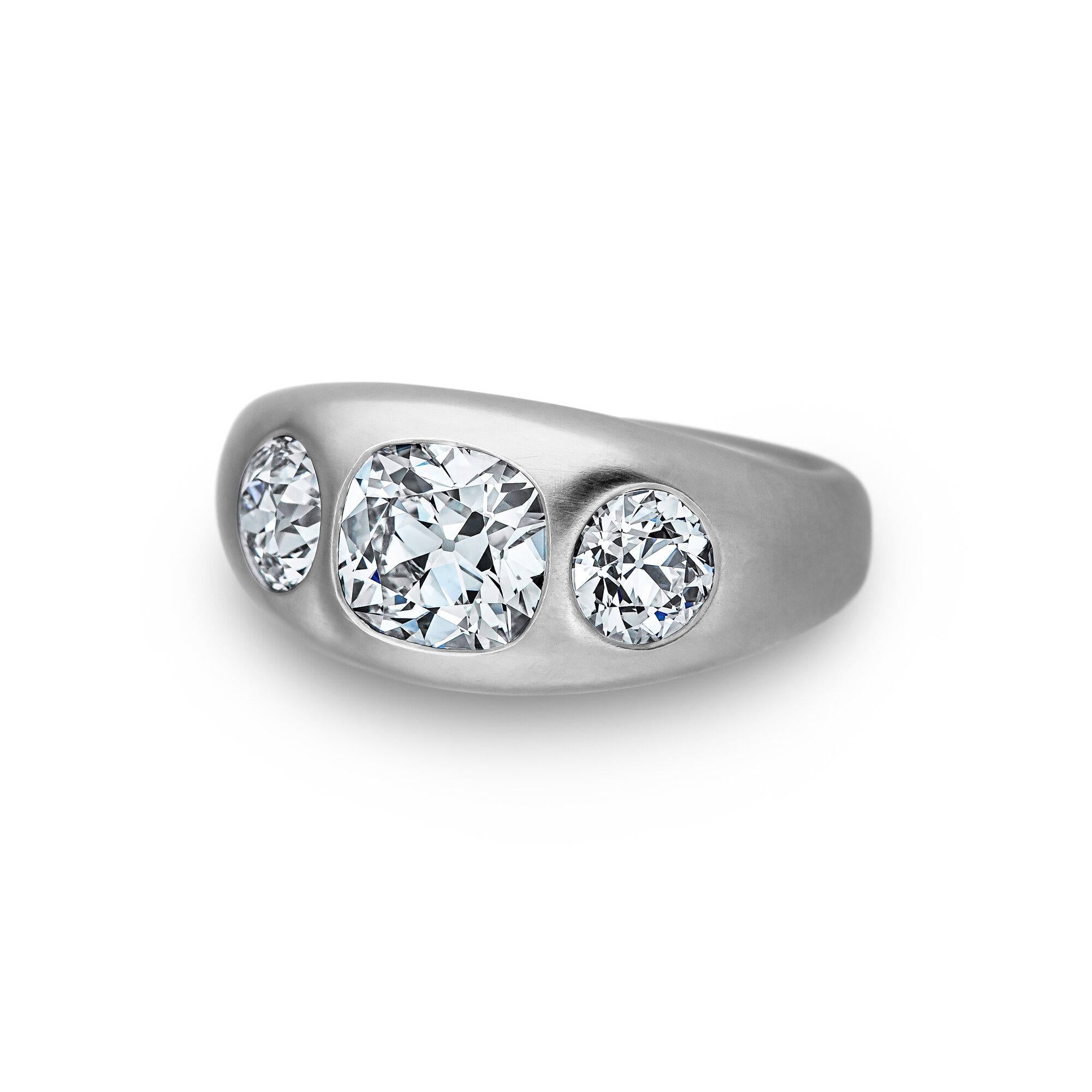 It's a triple header! With two scintillating old euro round cut diamonds surrounding one cushion brilliant cut center diamond, this handmade three stone matte finished platinum burnished set ring is a grand slam.  Designed by Steven Fox Jewelry. 
