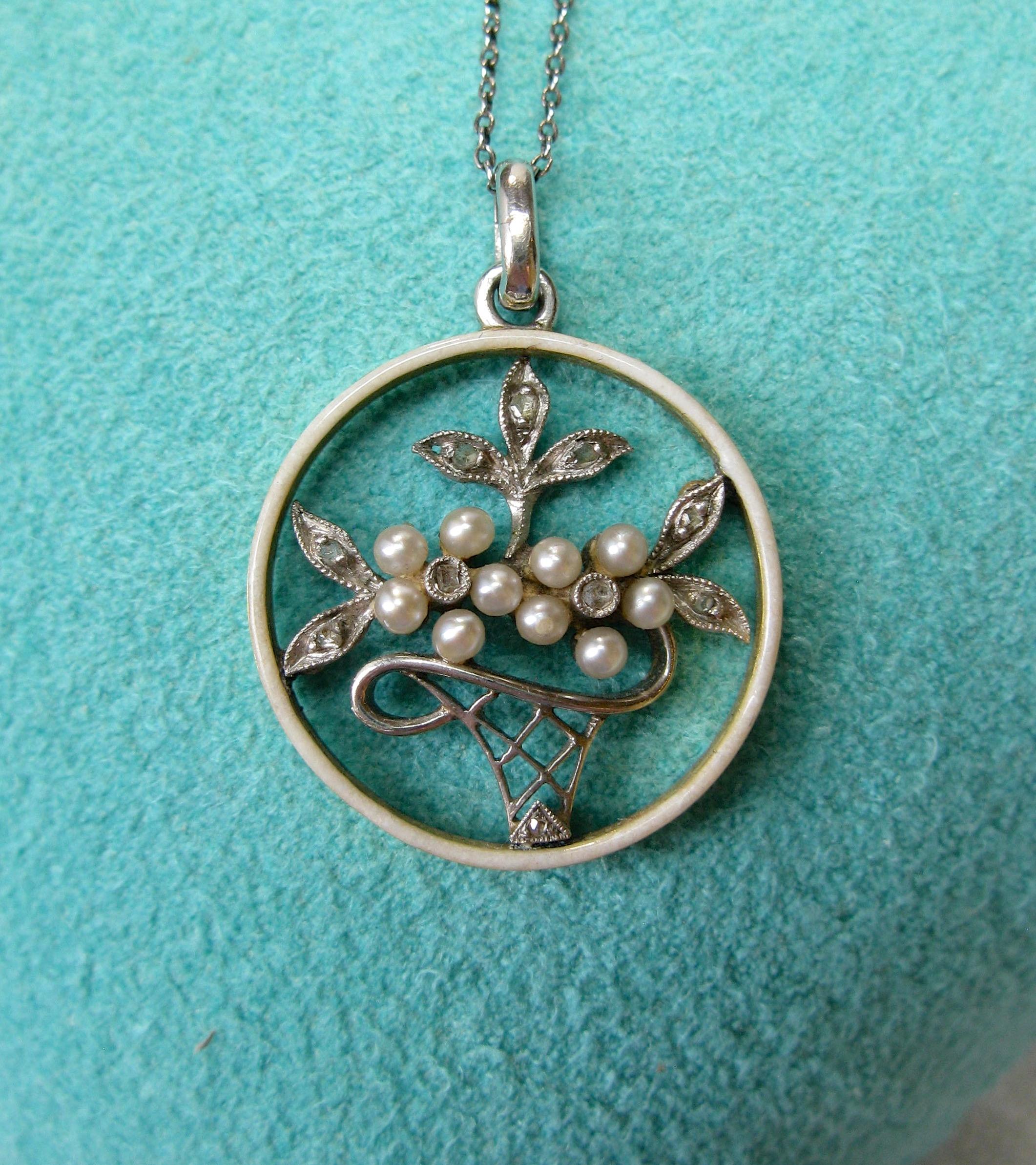 This is a stunning Rose Cut Diamond, Pearl, Platinum and Enamel pendant necklace in the form of a flower basket.  
The jewel is a museum quality antique Edwardian - Victorian necklace with delicate romantic grace and beauty.  The flower basket is