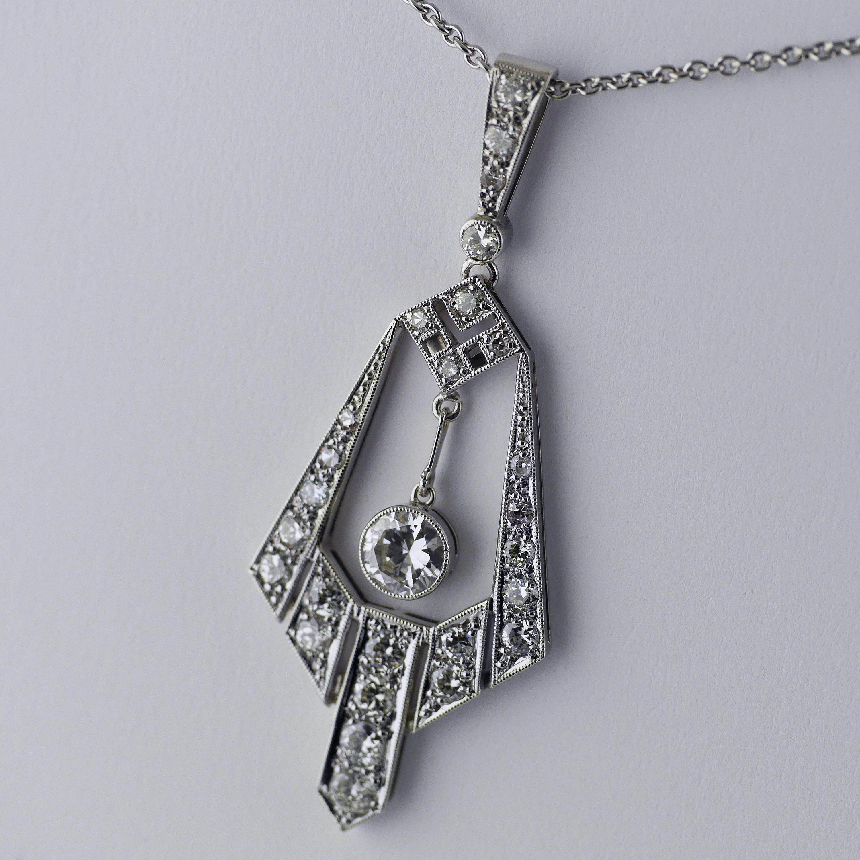 Platinum & 18ct white gold diamond pendant in the Art Deco Egyptian Revival style dated circa 1970 on a platinum chain.

Articulated central diamond drop, 0.50ct (approx), Natural Light Brown colour, VVS1 – VS1.

Mix of round Edwardian cut diamonds,