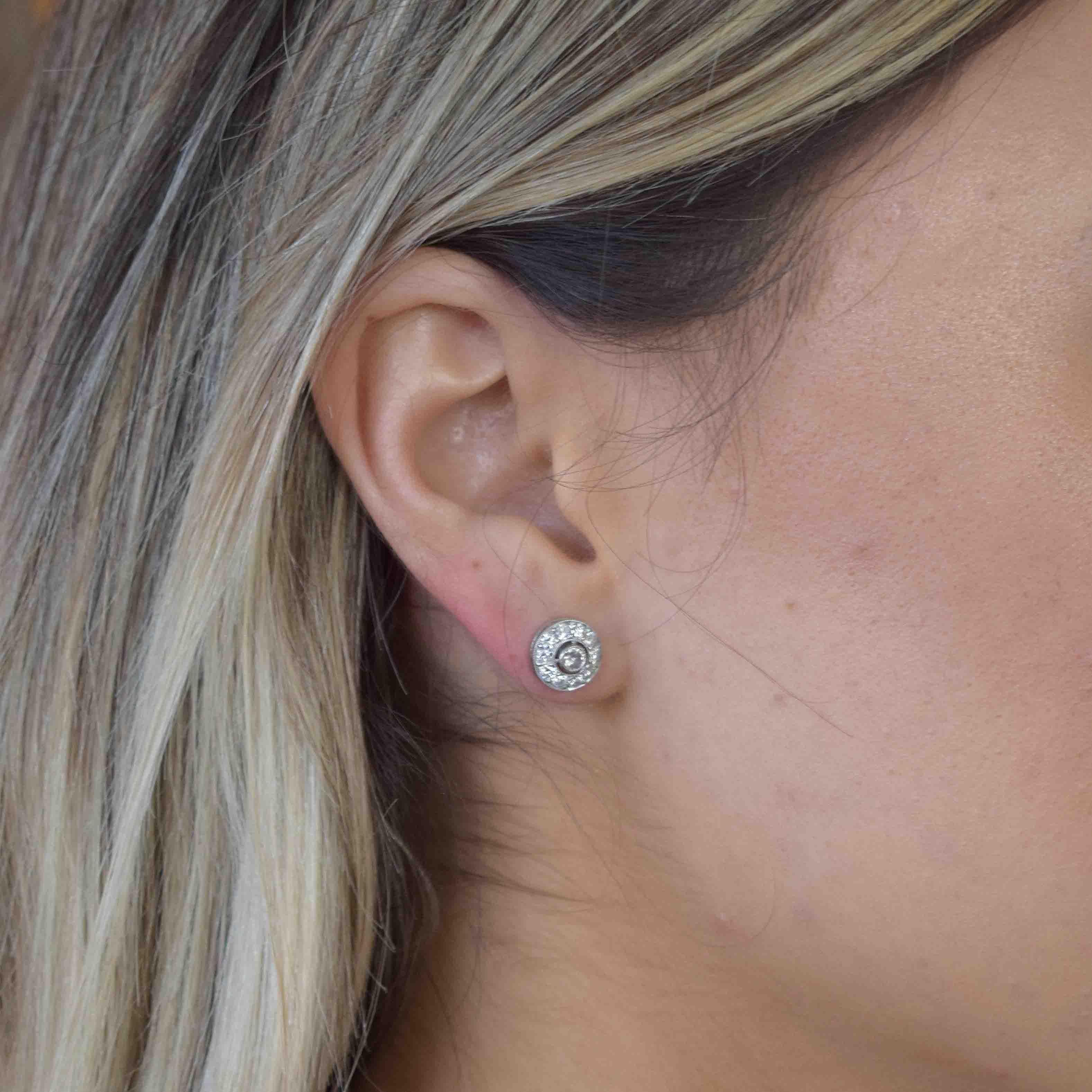 Diamond stud earrings can be worn anytime, anywhere. These stud earrings have the bonus feature of being surrounded by 10 round diamonds. Crafted in platinum.