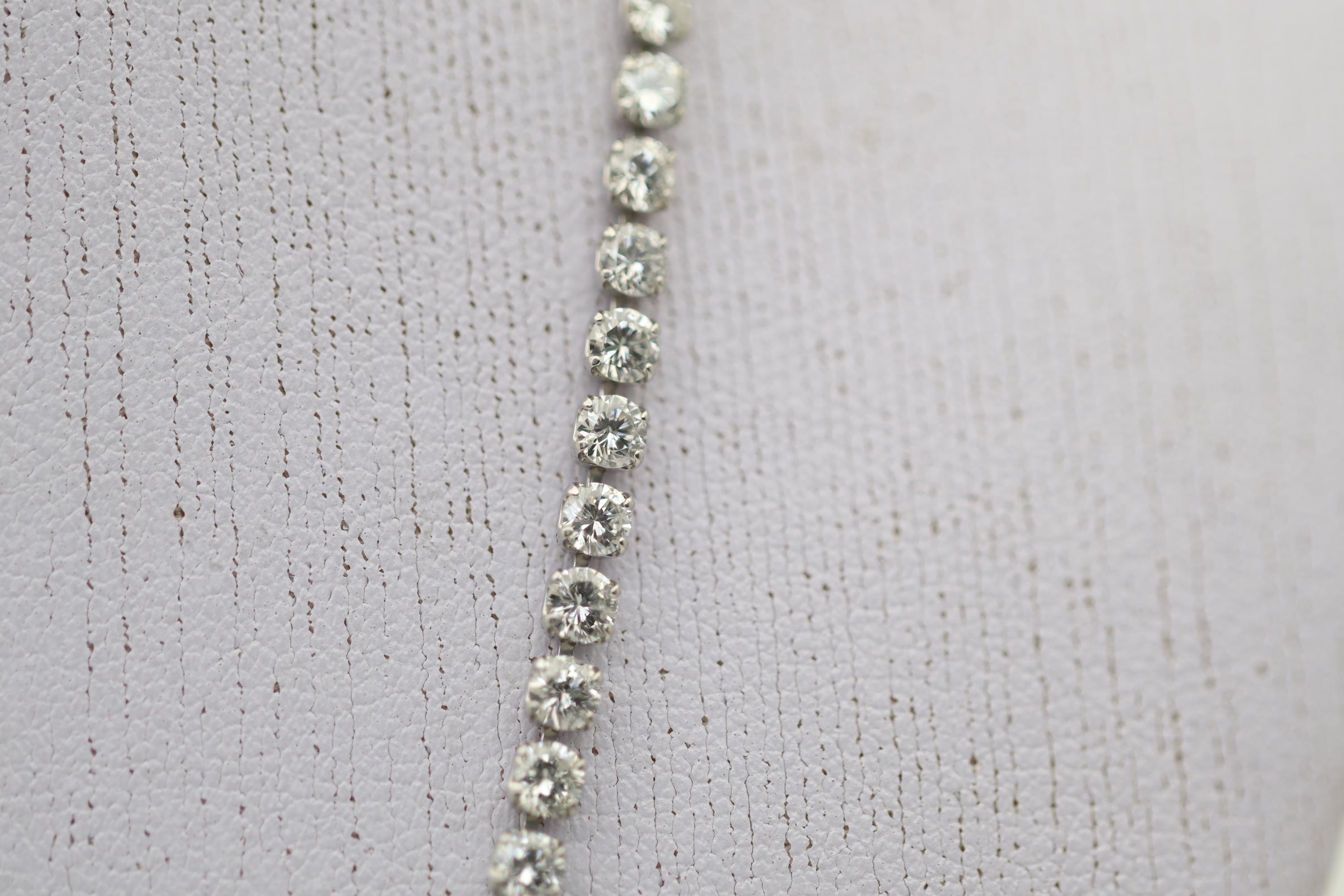 A classic and stylish tennis necklace featuring 10 carats of fine bright white diamonds! They are set in a straight line in strong durable platinum and lays perfectly flat on the neck-line. Made in platinum and ready to be worn.

Length: 16.5