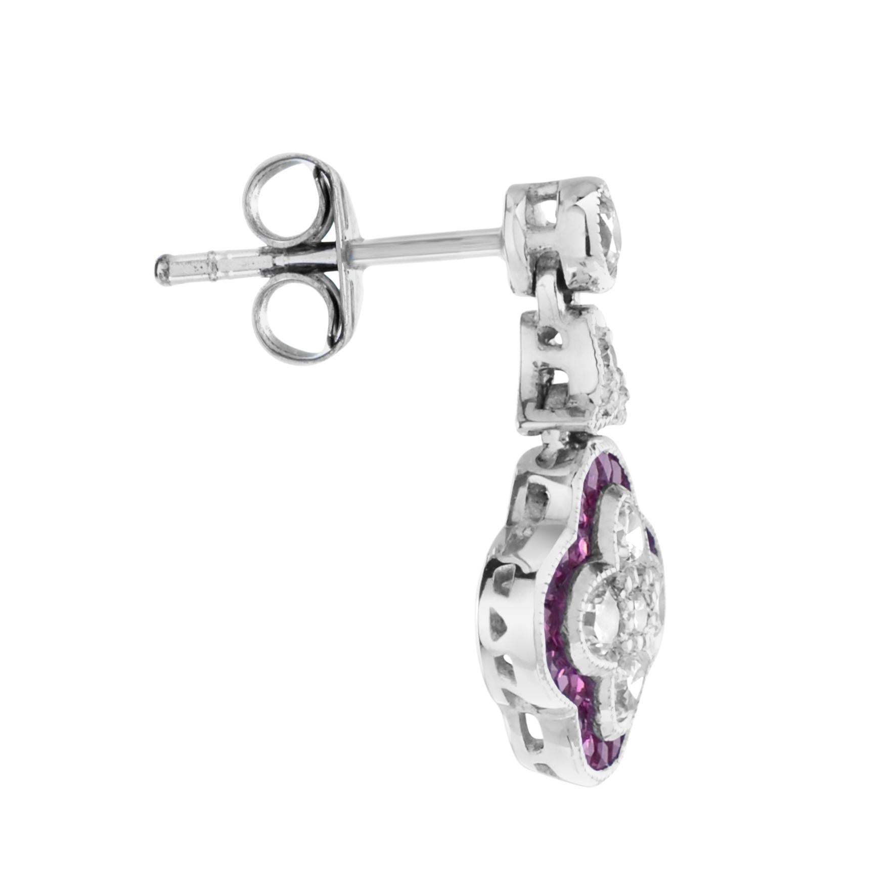 Un bel paio di orecchini per chi ama i gioielli di ispirazione antica. Realizzato con diamanti taglio rotondo e rubini taglio francese incastonati su oro 18 carati. Un totale di quattordici diamanti formano un fiore con un design rifinito con un