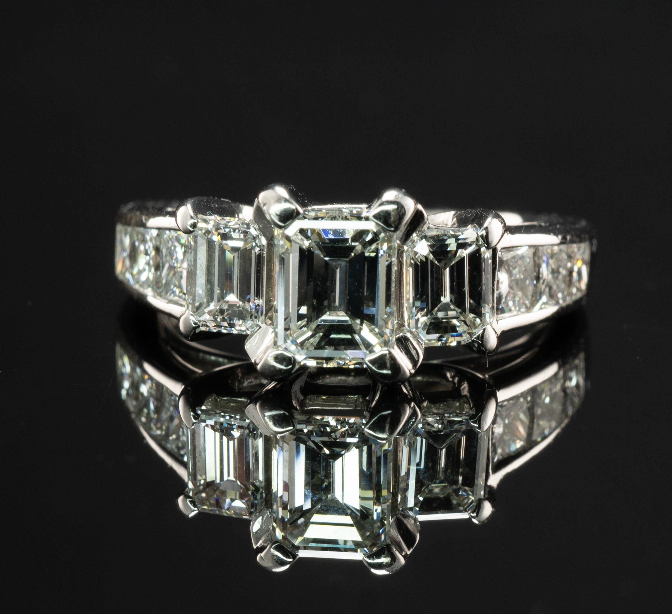 Diamond Ring 18K White Gold Band  2.00 cts TDW Three Emerald cut

This solid 18K White gold estate ring would make a marvelous engagement ring or wedding ring.
The center emerald cut genuine diamond is .70 Carat (6x4.75mm).
Two diamond baguettes