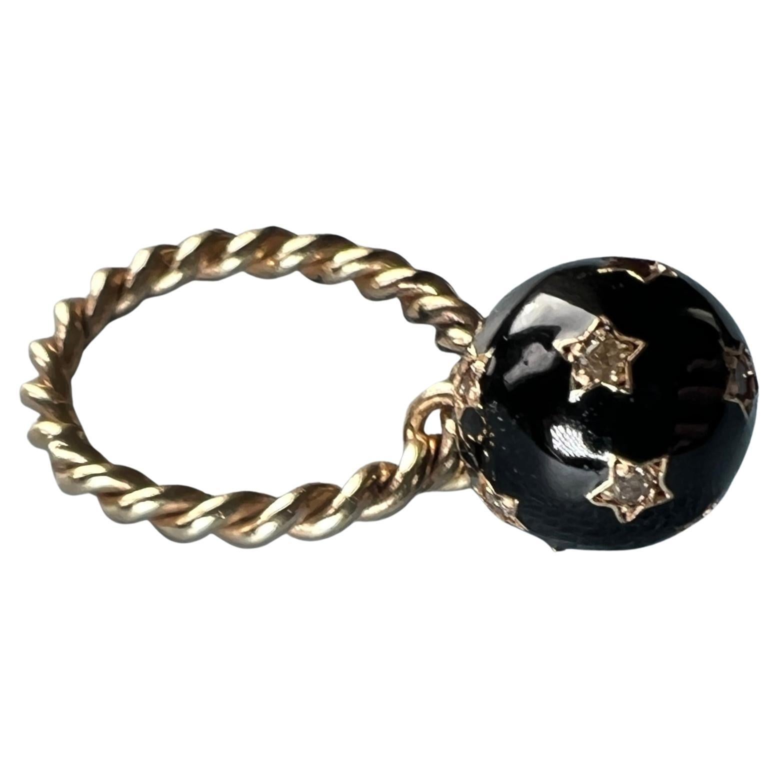 Diamond Sphere Dangle Ring Black Enamel Sphere covered in stars. The sphere moves on the ring. 

Ring with black Enamel, inspired by Victorian Age, Memento Mori

Designer: J Dauphin

The sphere as a symbol often represents completeness, wholeness,
