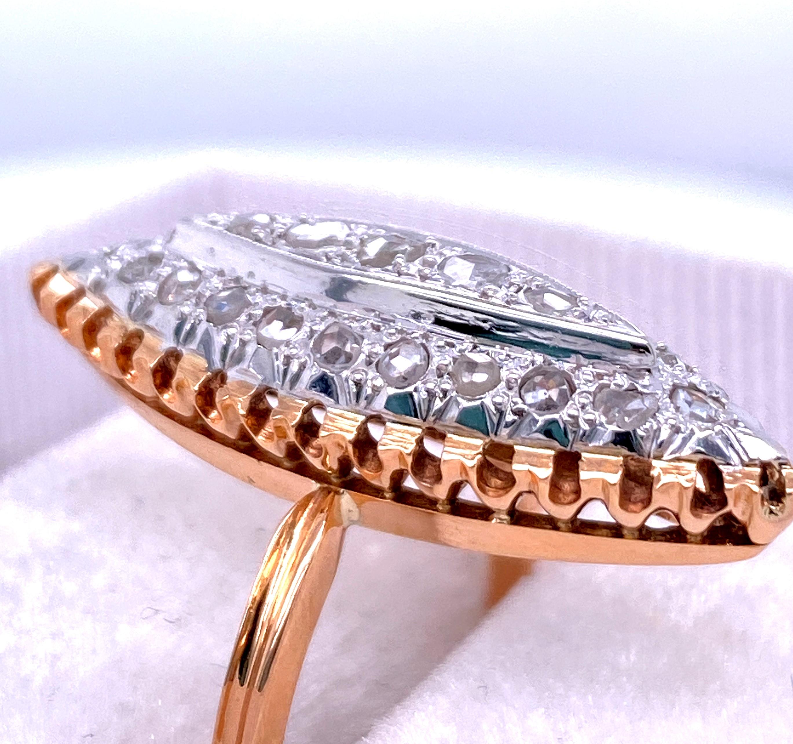 One 18 karat yellow and white gold (stamped K18) marquise shaped ring pave set with twenty-five native cut diamonds with J-L color and SI2/I1 clarity. The top measures 28mm x 10mm and the yellow gold shank tapers from 1.9mm to 1.36mm. The ring is a