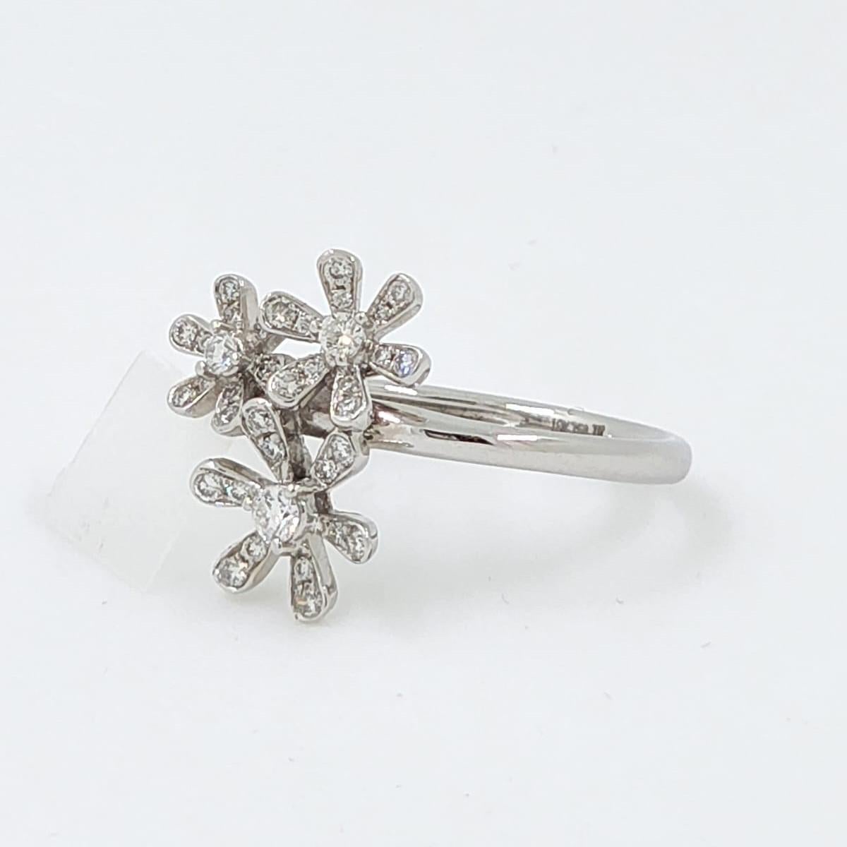 Delicate and enchanting, this floral-inspired ring is crafted in luminous 18 karat white gold and set with 0.29 carats of round brilliant diamonds. Three daisy-like clusters form a whimsical bouquet atop the slender band, with each petal outlined in