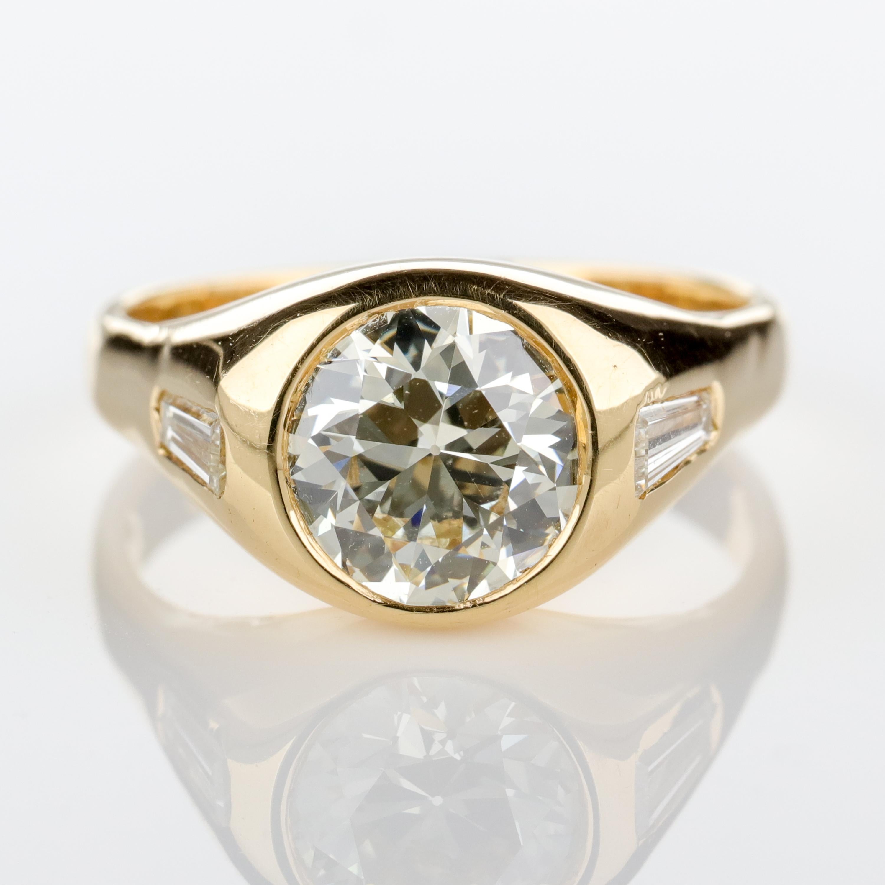 This vintage—circa 1960's—18k yellow gold ring features a firey 2-carat old European-cut diamond of excellent color (L-M) and clarity (VS). Two 4.4 mm x 2.3 mm tapered baguette diamonds sharpen the shoulders. This is a beautifully-cut old diamond