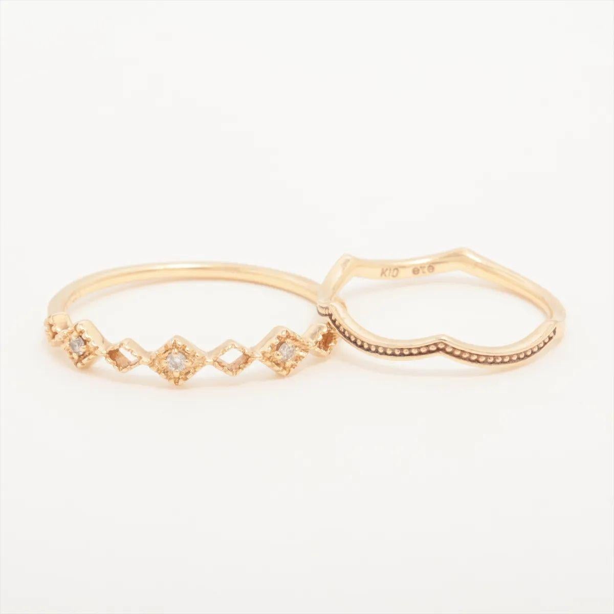The ete Diamond Ring Set in yellow gold is a delicate and contemporary pairing that exudes understated elegance. Crafted from polished yellow gold, one ring features a sleek diamond-shaped design accented with a sparkling diamond, while the other