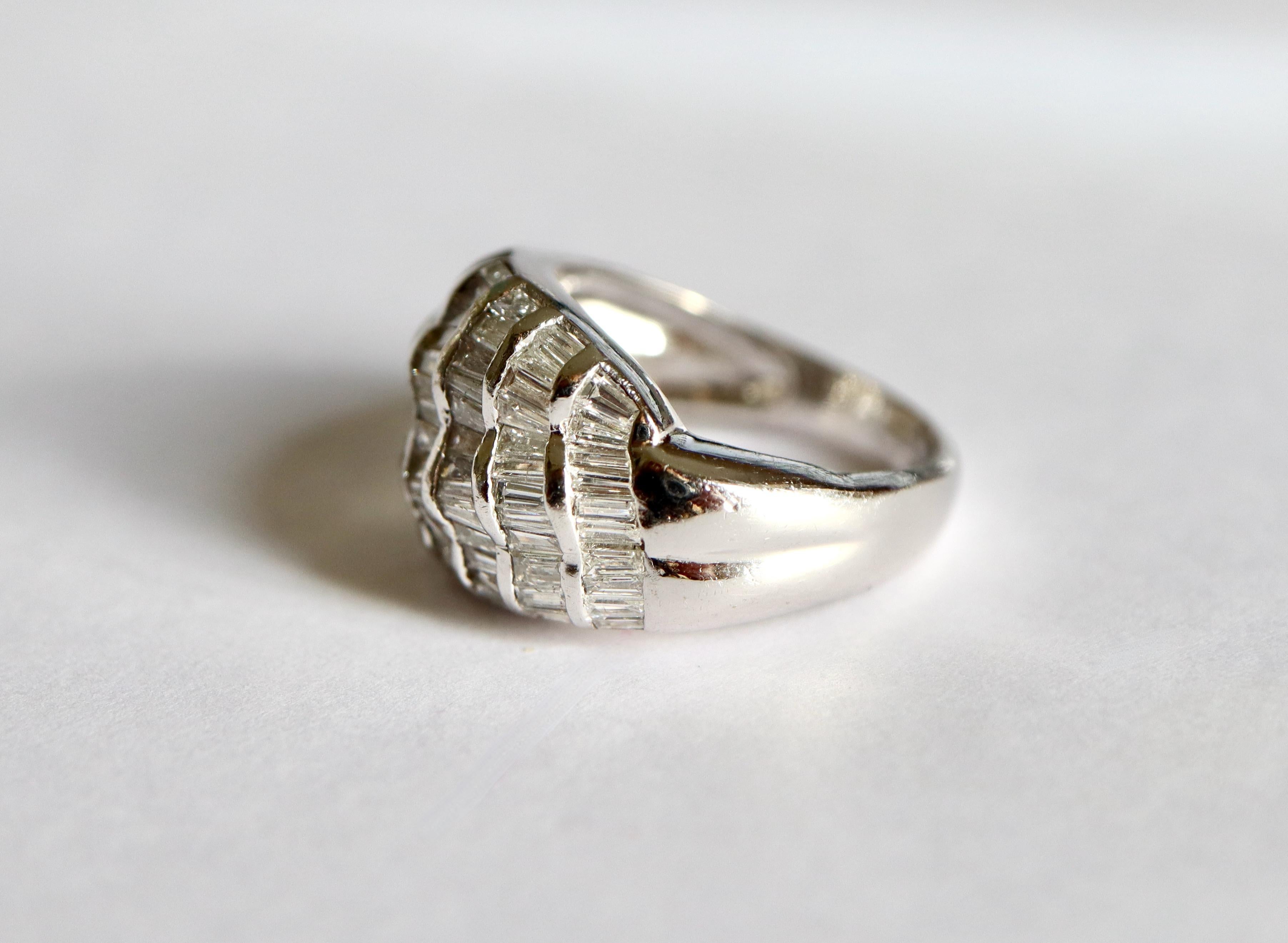 Ring aus 18 Karat Weißgold mit einem Wellenmuster, das mit Diamanten ausgefasst ist. 7 Reihen mit Baguette-Diamanten mit einem Gesamtgewicht von 1,3 bis 1,5 Karat.
Durchmesser: 16,5 mm FR Größe 52 US Größe : 6
Französische Punze : Adlerkopfpunze für