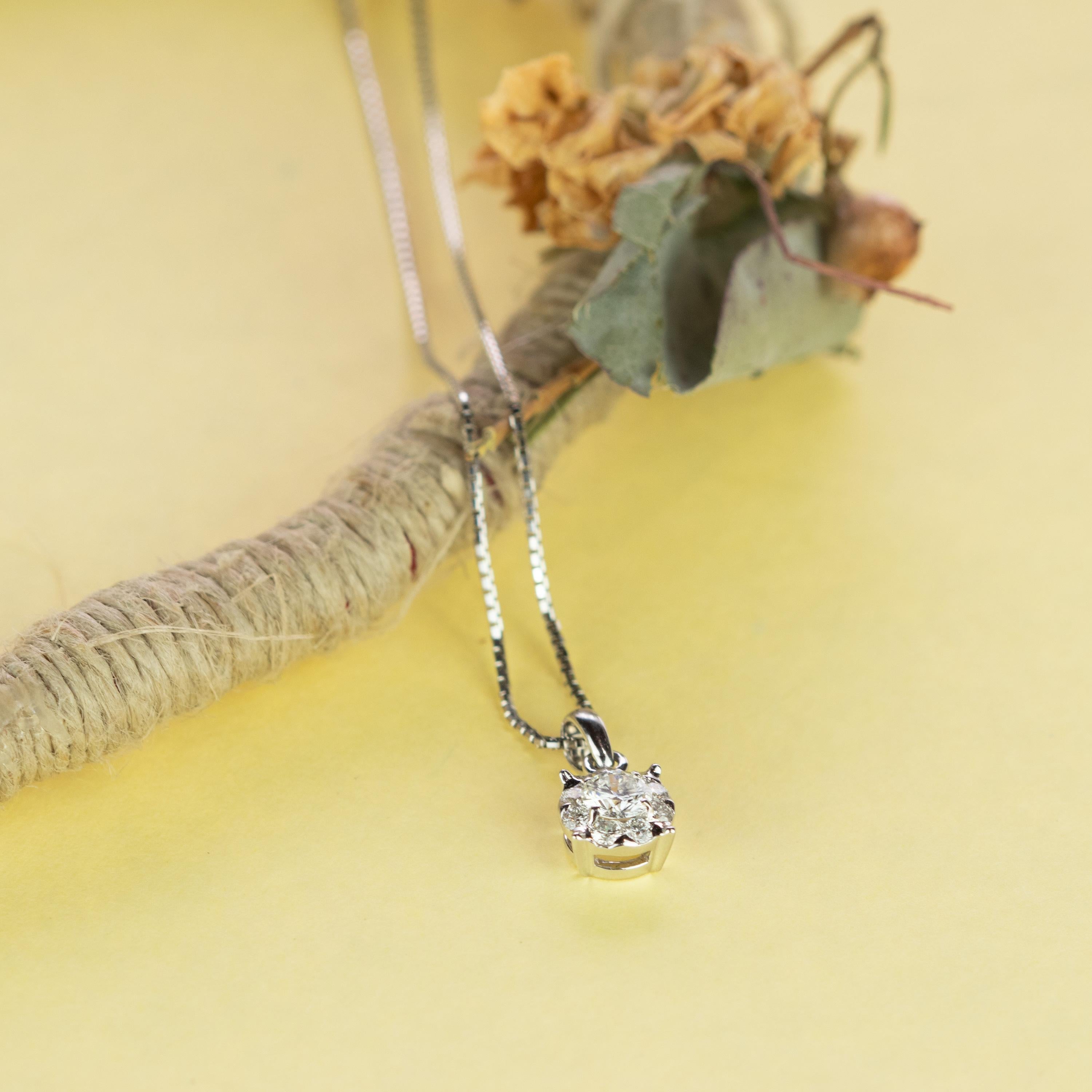 Un magnifique diamant solitaire italien rond central de 0,29 carats entouré de 8 autres diamants pour 0,23 carats (total 0,52 carats). La précieuse composition est sertie dans une pièce en or blanc 18 carats et retenue par une chaîne de 42 cm en or