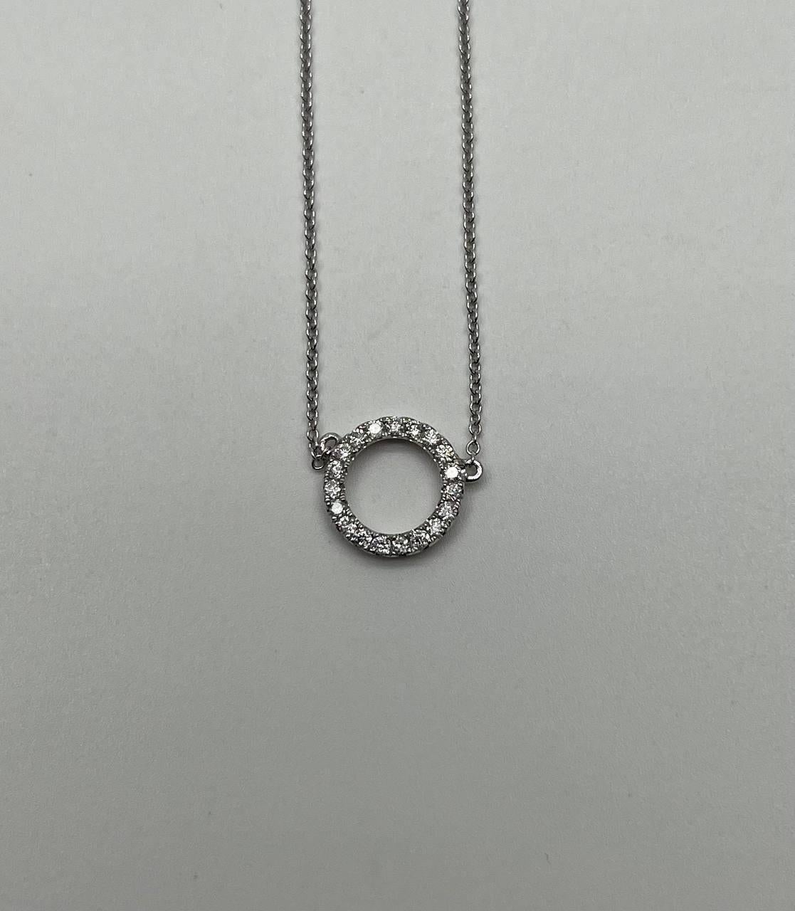 Collana con ciondolo a cerchio in oro bianco 18K con un motivo circolare incrostato di diamanti rotondi taglio brillante (0,20 carati). Sospeso su una delicata catena.