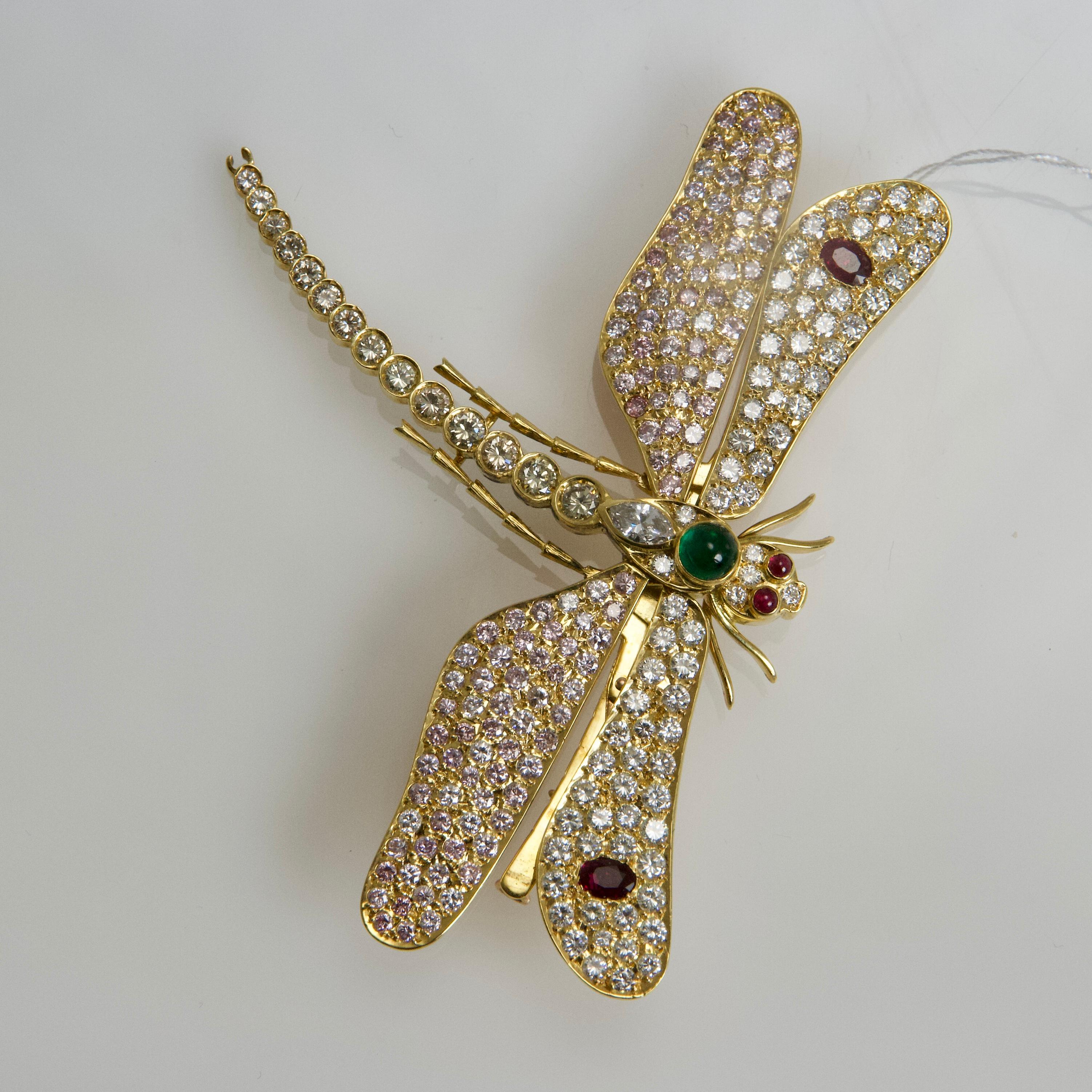 Large brooch representing a dragonfly with moving wings entirely set with rounds diamonds, pink sapphires, four  rubies, one marquise cut diamond and  one cabochon emerald. 
Diamonds weight approximately 6 carats. 
Made in France circa 1960
