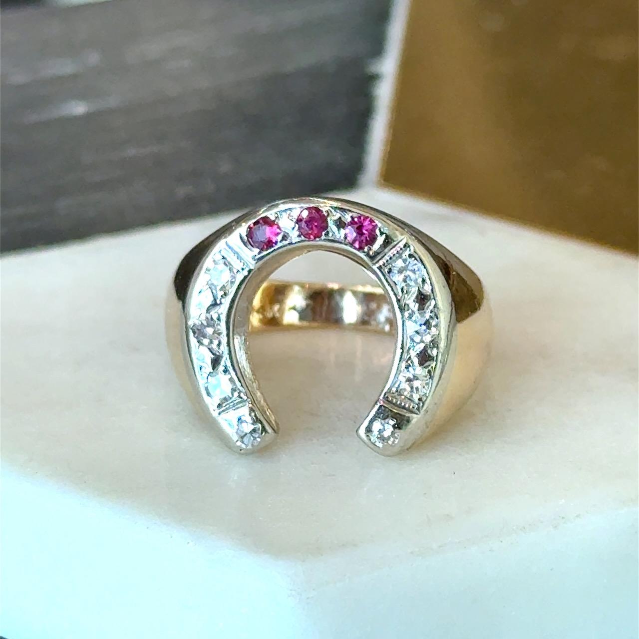 Awesome 1940's Horseshoe Ring
8 - Sparkly Round Diamonds
3 - Round Rubies
8 grams 14kt Yellow and White Gold
Size 6 and Can be Sized  
The Top is 16mm x 8mm 

Why we love it: We love symbolic jewelry, and the horseshoe is a universal symbol of good